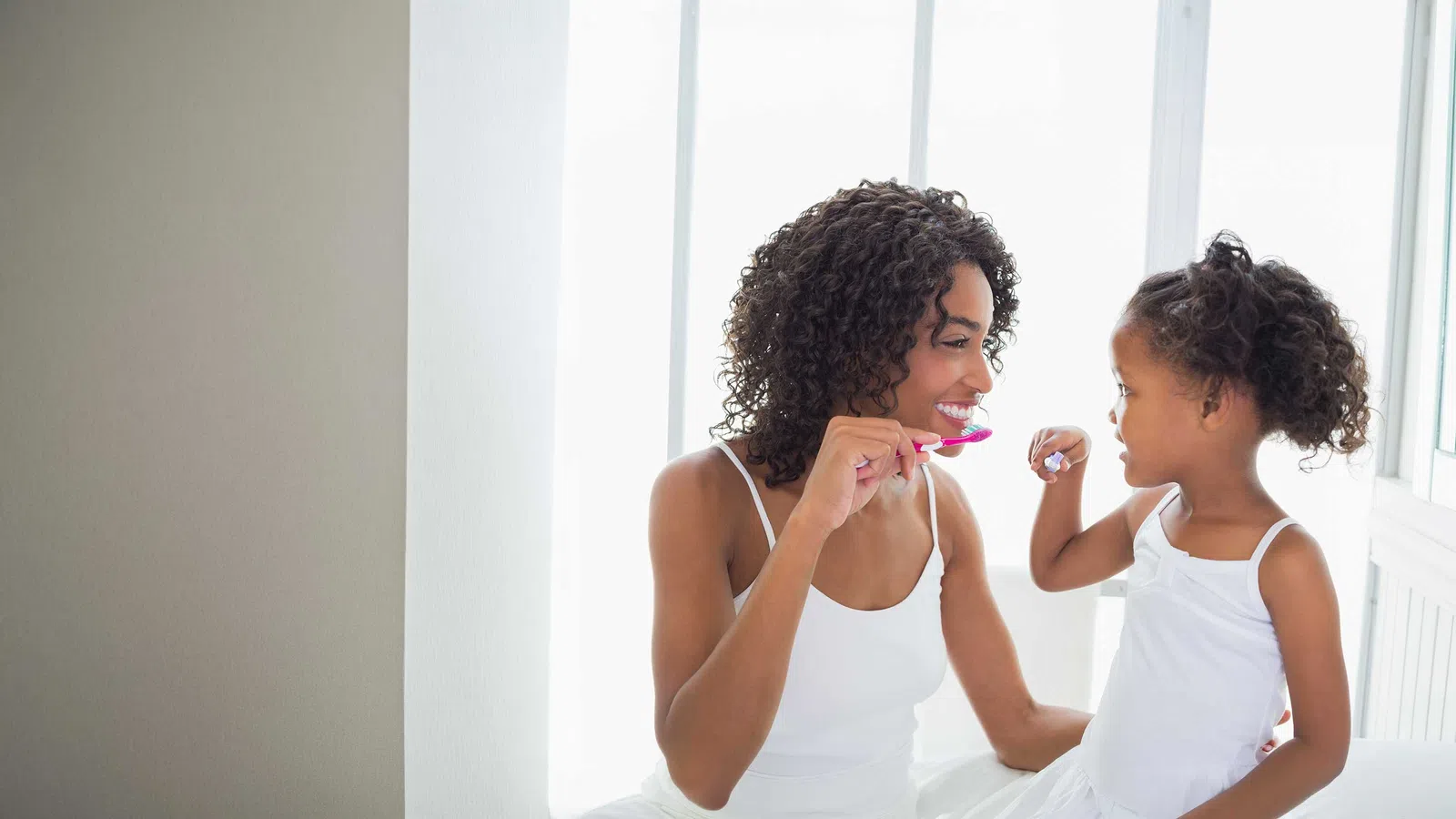 a woman brushing another woman's teeth