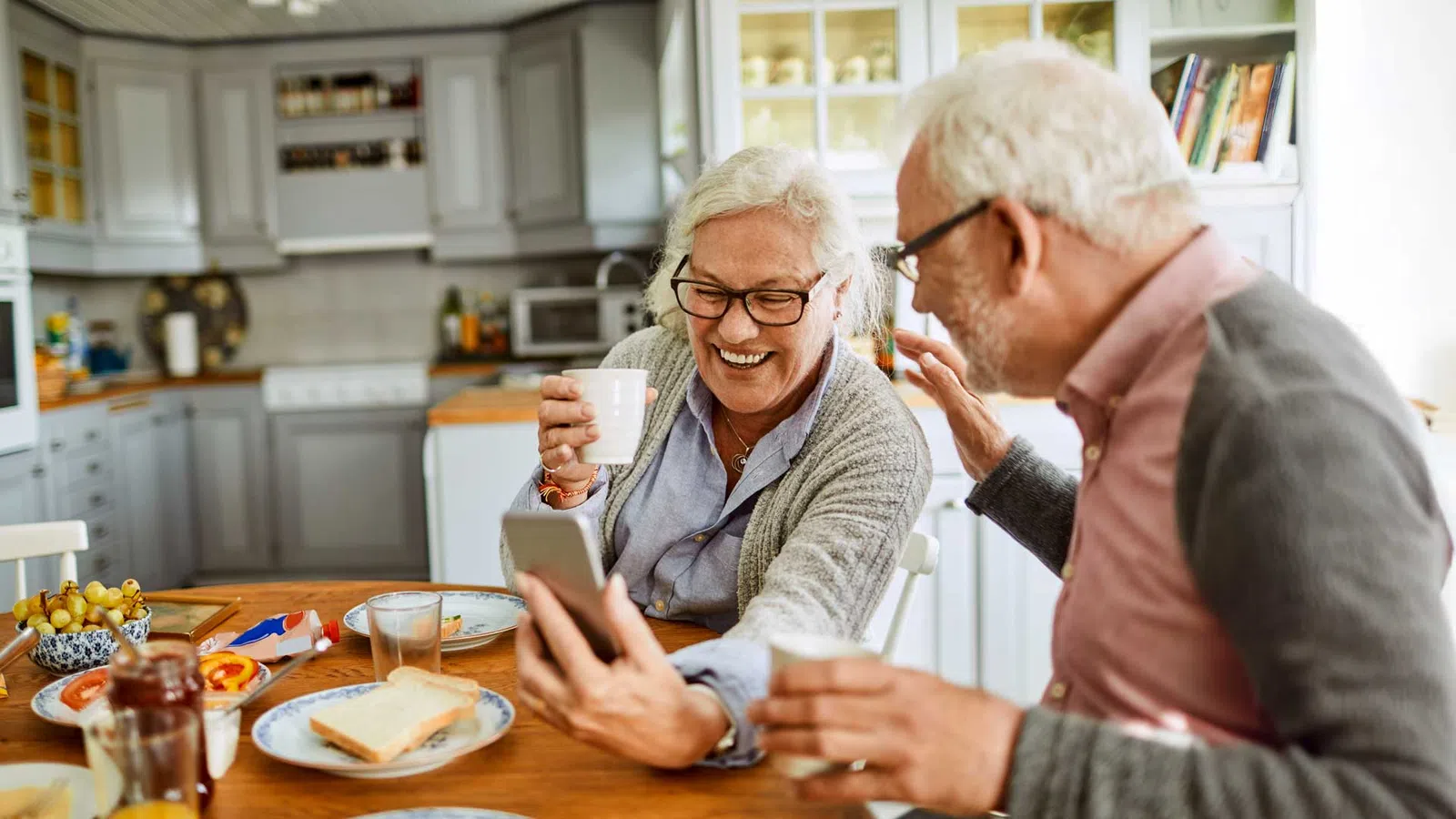 a man and woman sitting at a table and smiling