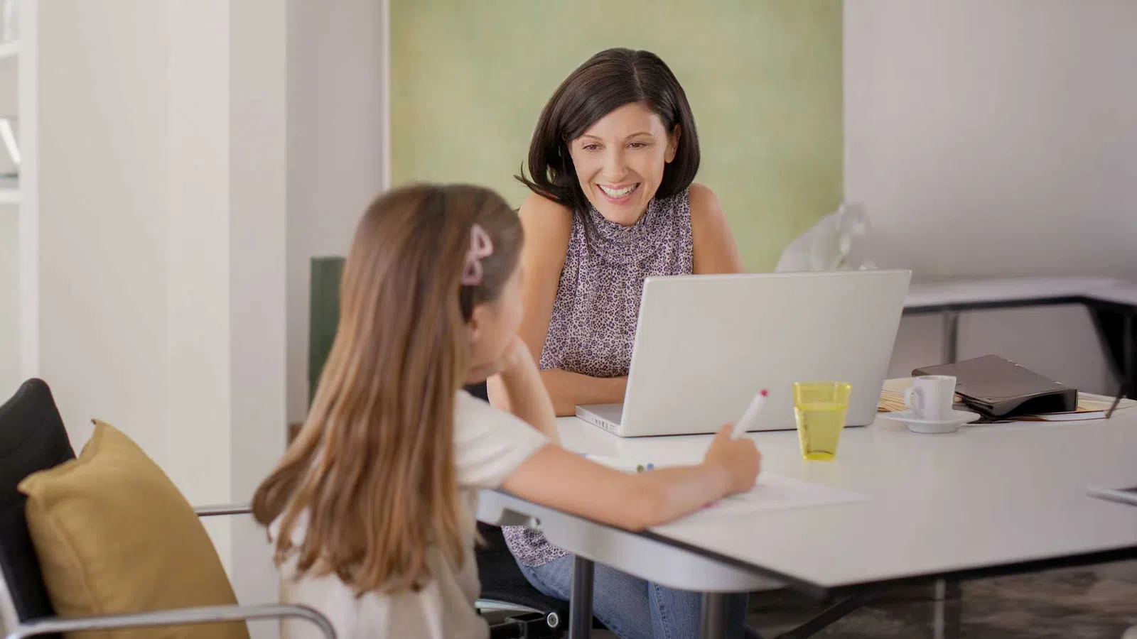 a woman showing a woman something on the laptop
