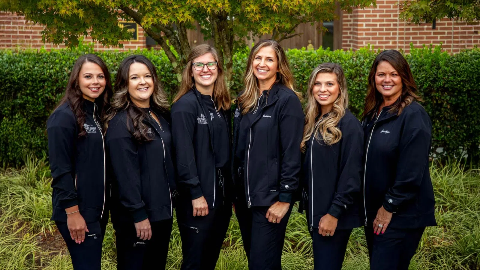 a group of women standing in front of a dental office