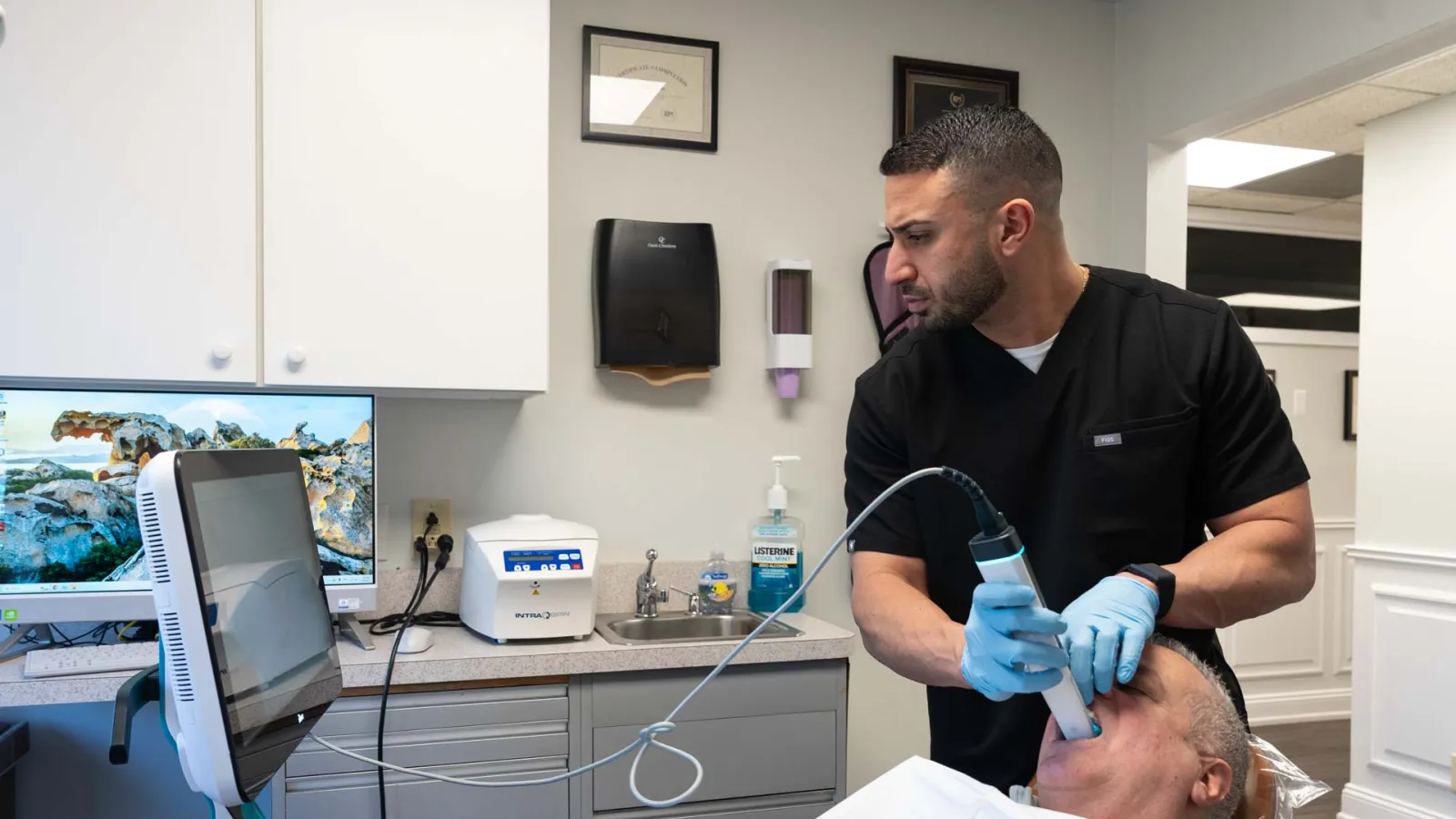 Dentist using advanced digital scanner to examine a patient's mouth in a modern dental clinic.