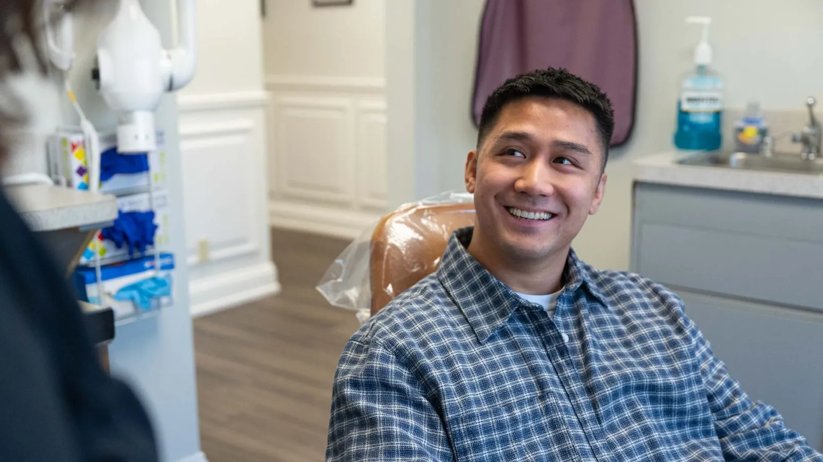 Smiling man sitting in dental chair during appointment in a modern dental office
