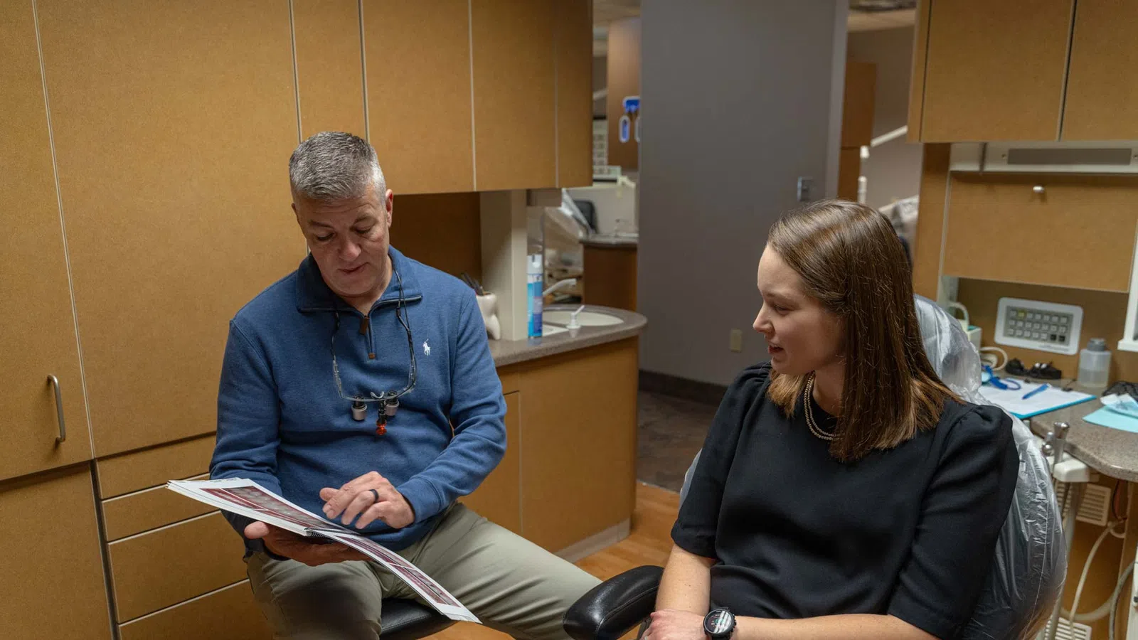 Dentist explaining dental treatment options to female patient in a modern dental office