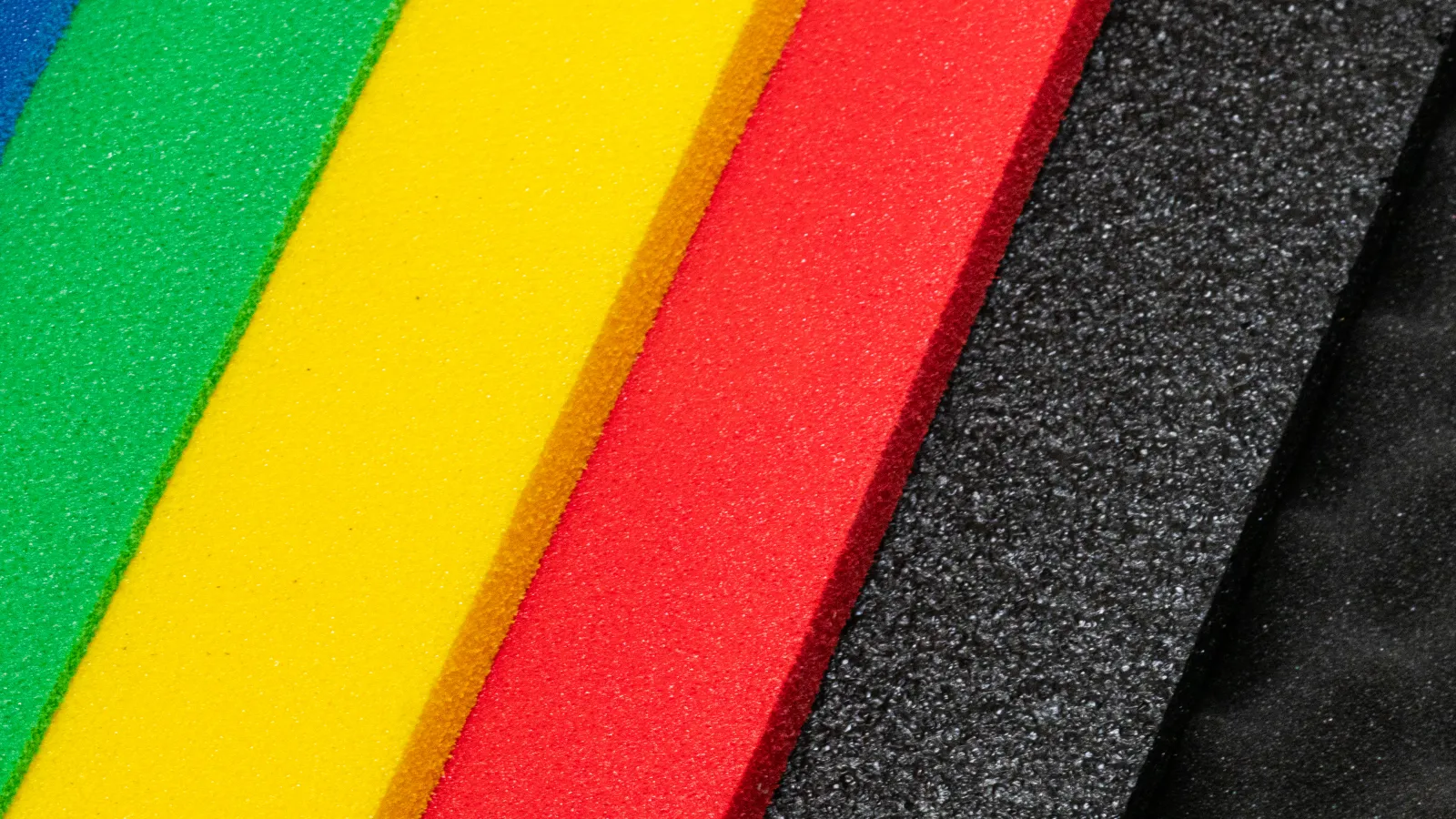 Close-up of foam sheets in blue, green, yellow, red, black, and textured black arranged diagonally.