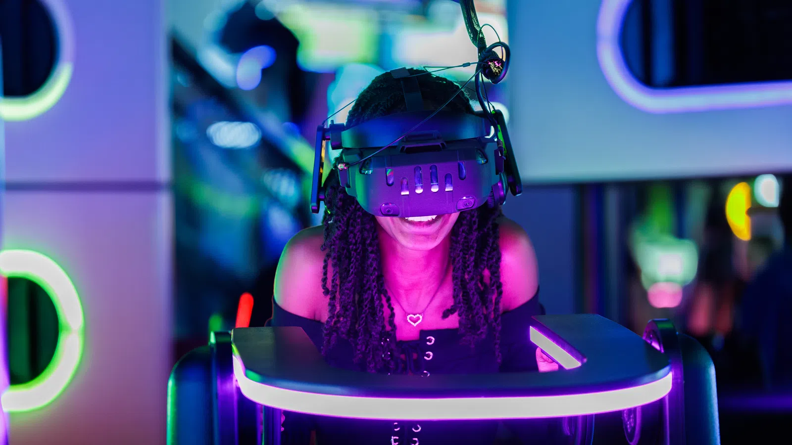 Young woman enjoying virtual reality gaming in neon-lit arcade with a VR headset and motion platform.
