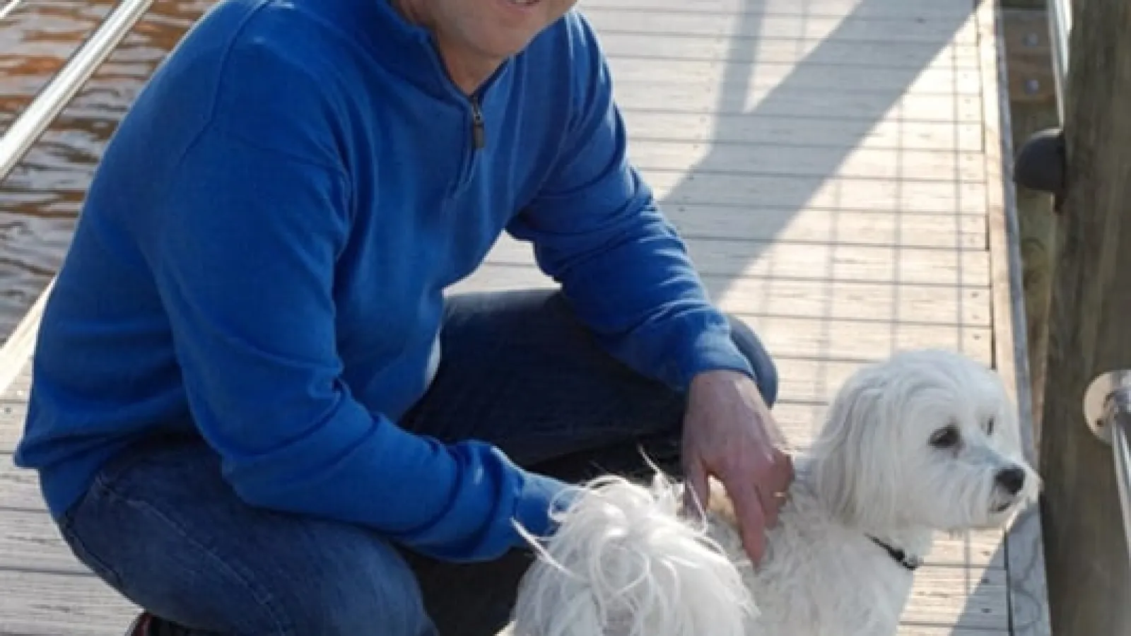 John Andretti kneeling down next to a dog