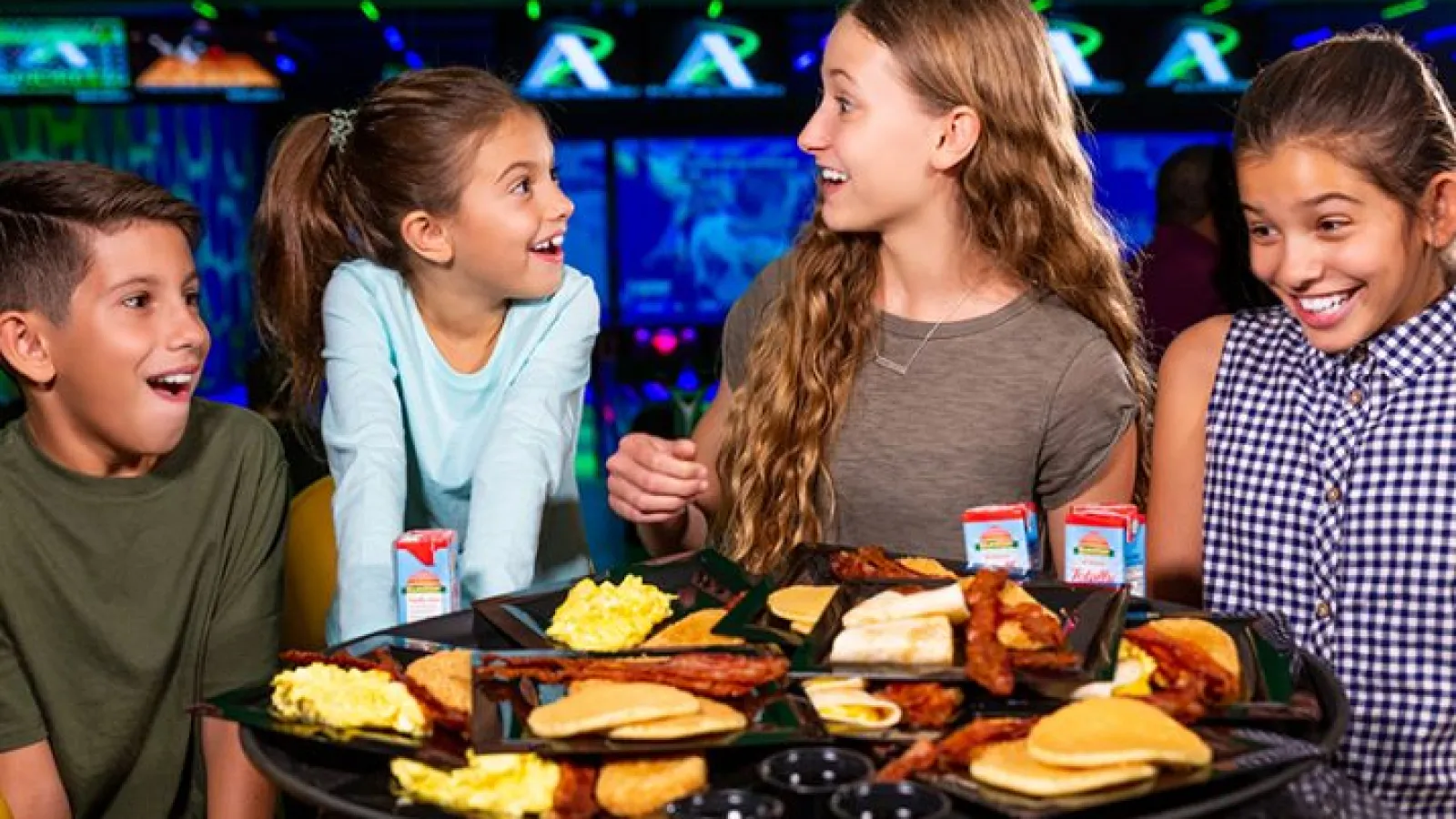 a group of people sitting at a table with food on it