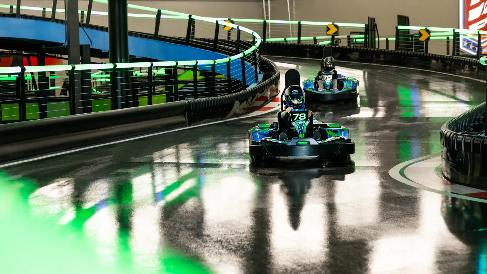 a group of toy cars on a track in a large indoor arena