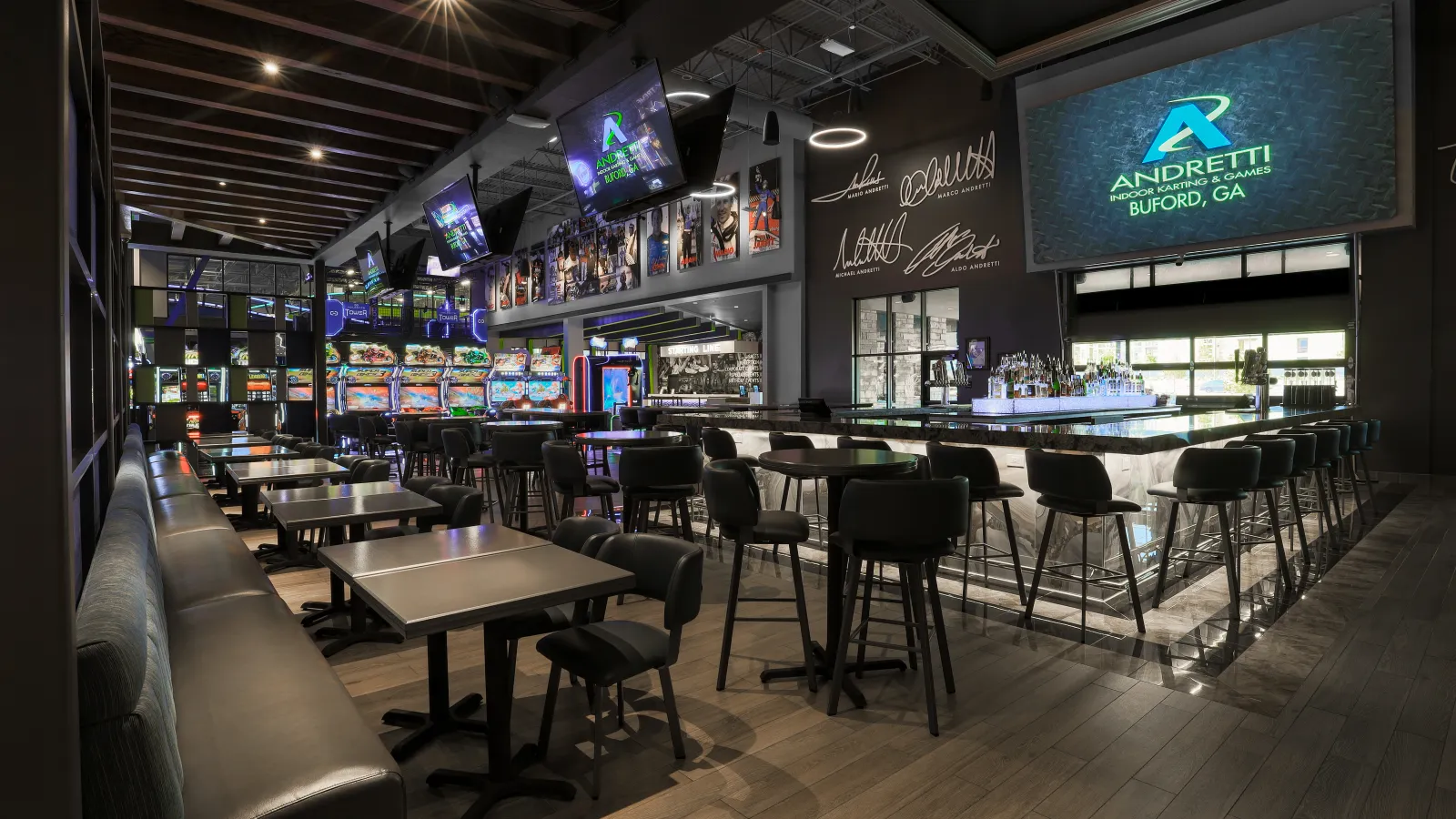 a bar with a large screen and chairs