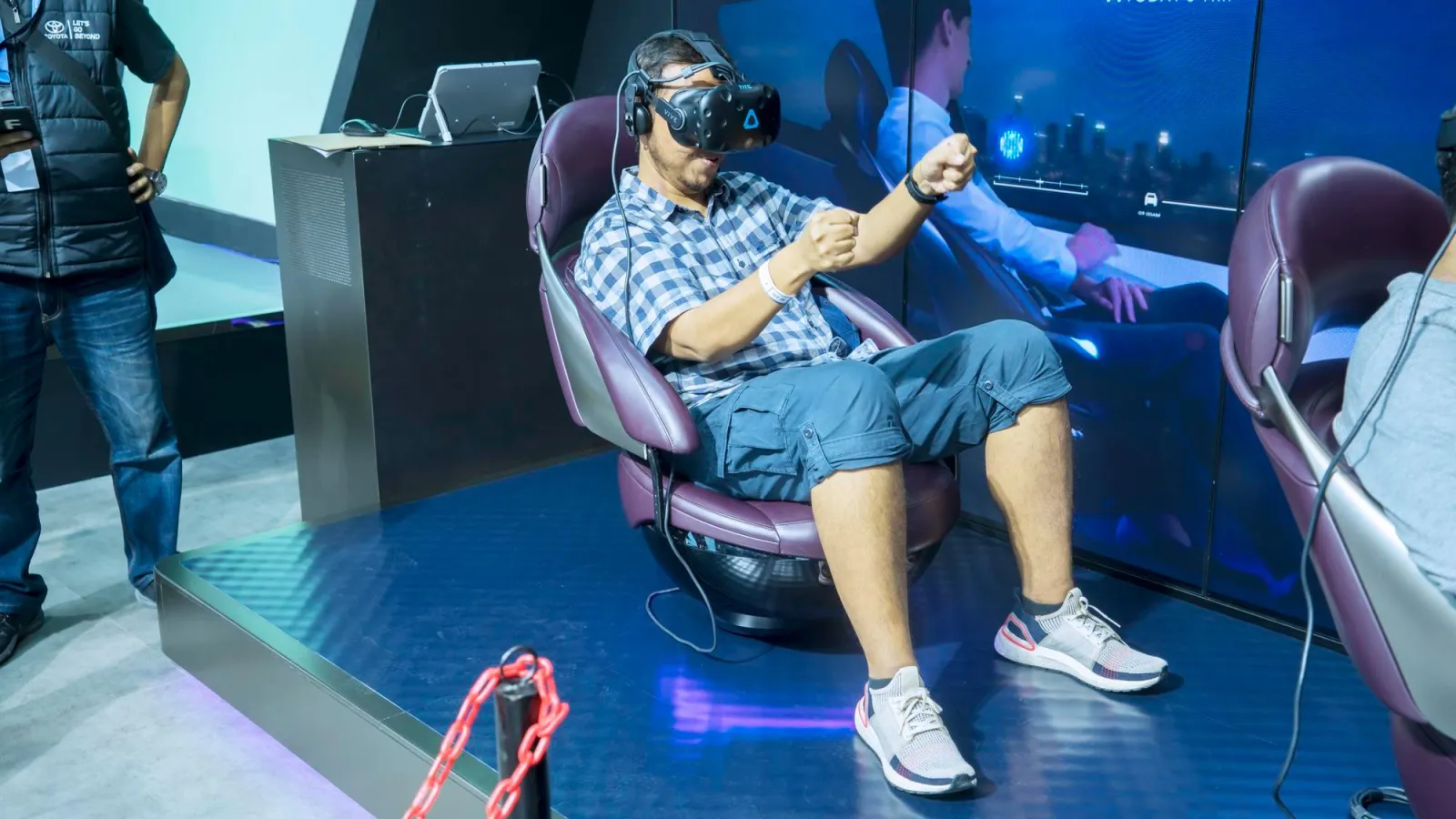 A person enjoying a virtual reality experience in a futuristic chair at an exhibition.