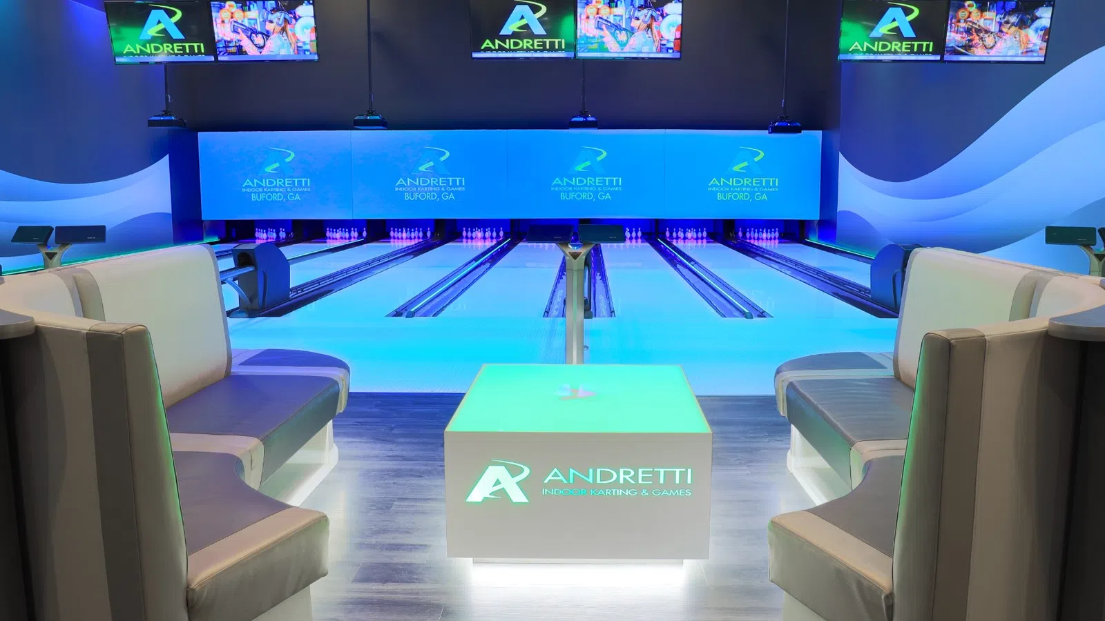 Modern bowling alley with illuminated lanes, cushioned seating, and Andretti branding in Buford, GA.