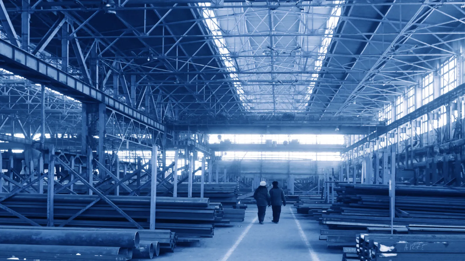 a couple of people walking in a large warehouse