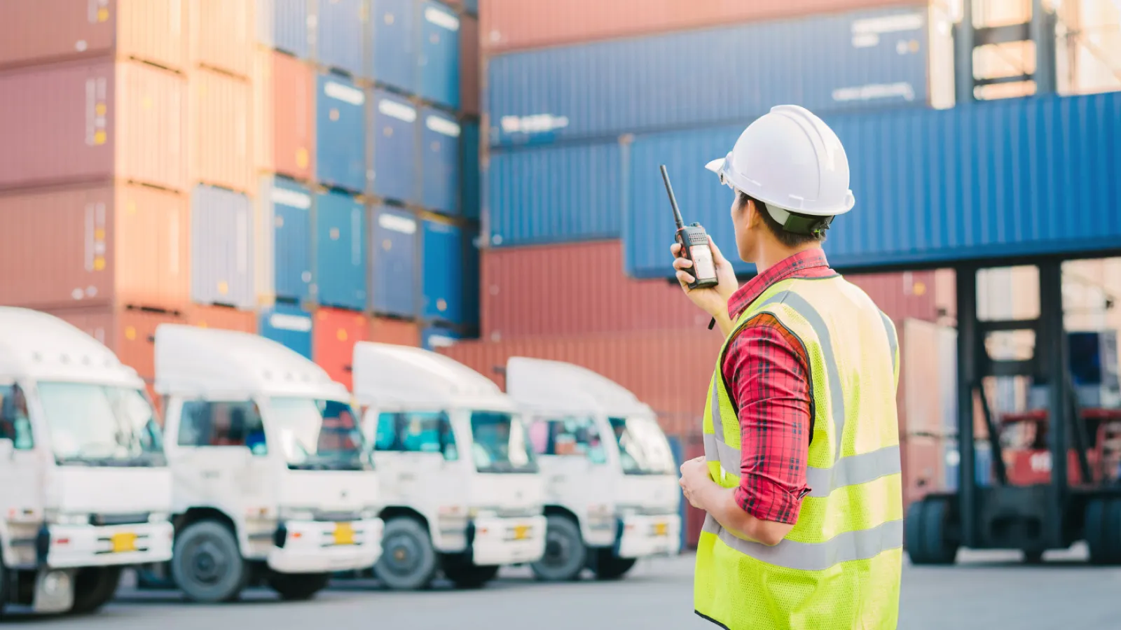 a person in a safety vest in front of a warehouse