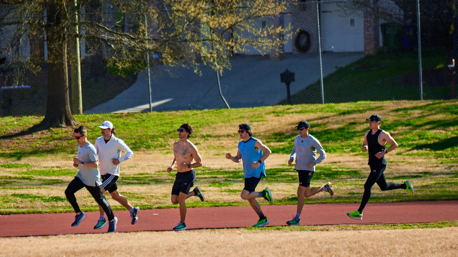 a group of people running on a dirt field