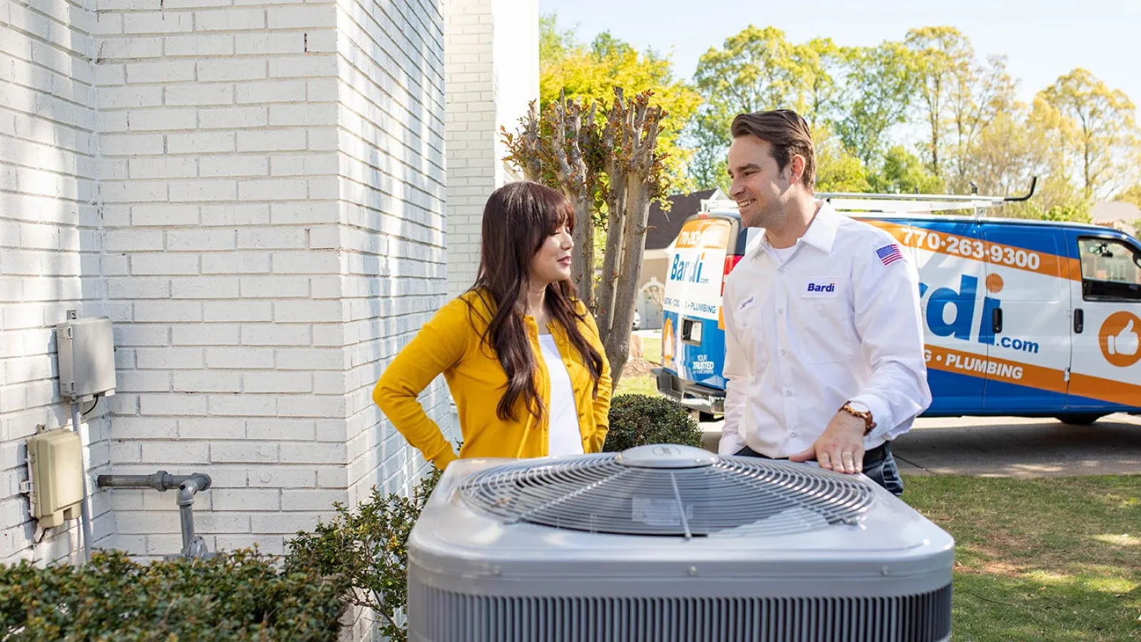 a man and a woman standing next to a car