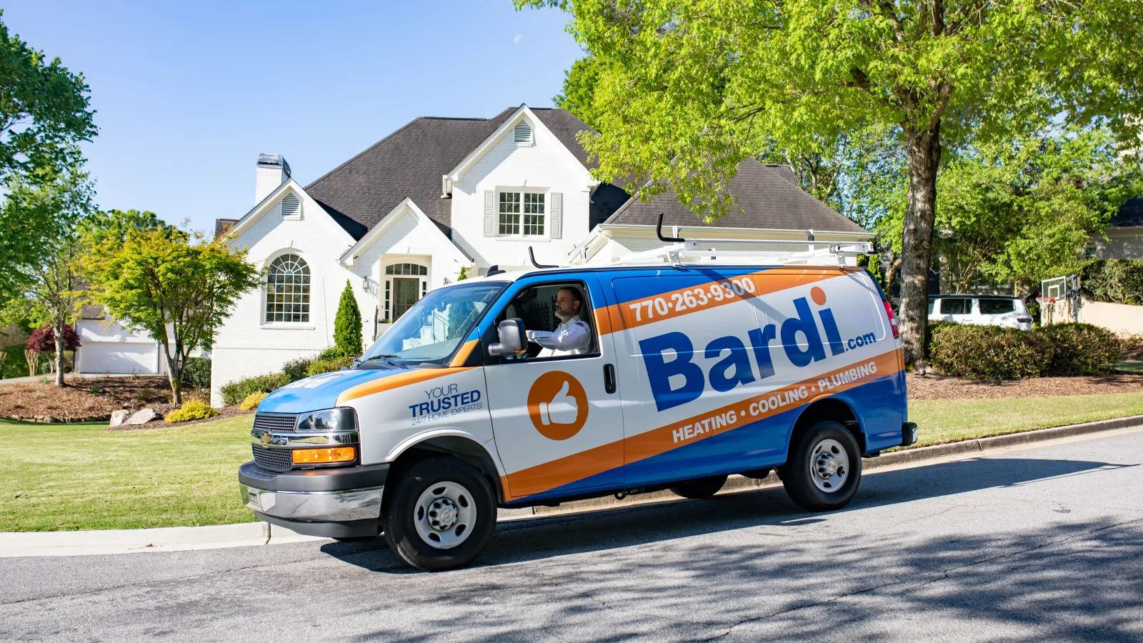 Bardi heating, cooling, and plumbing service van parked in front of a suburban house on a sunny day.