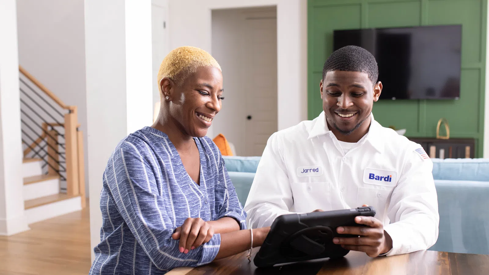 a man and a woman looking at a tablet