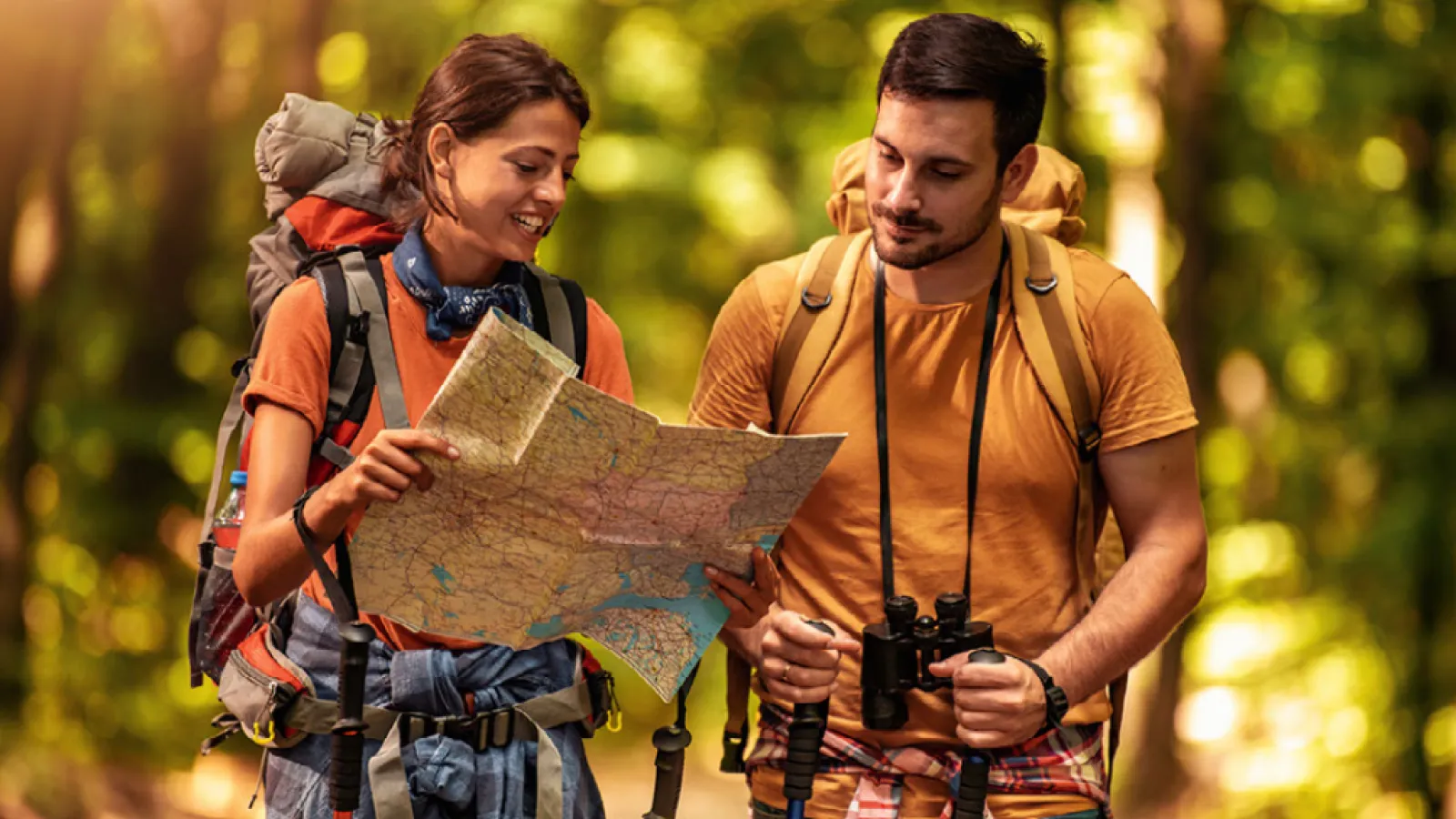 a man and woman with backpacks looking at a map