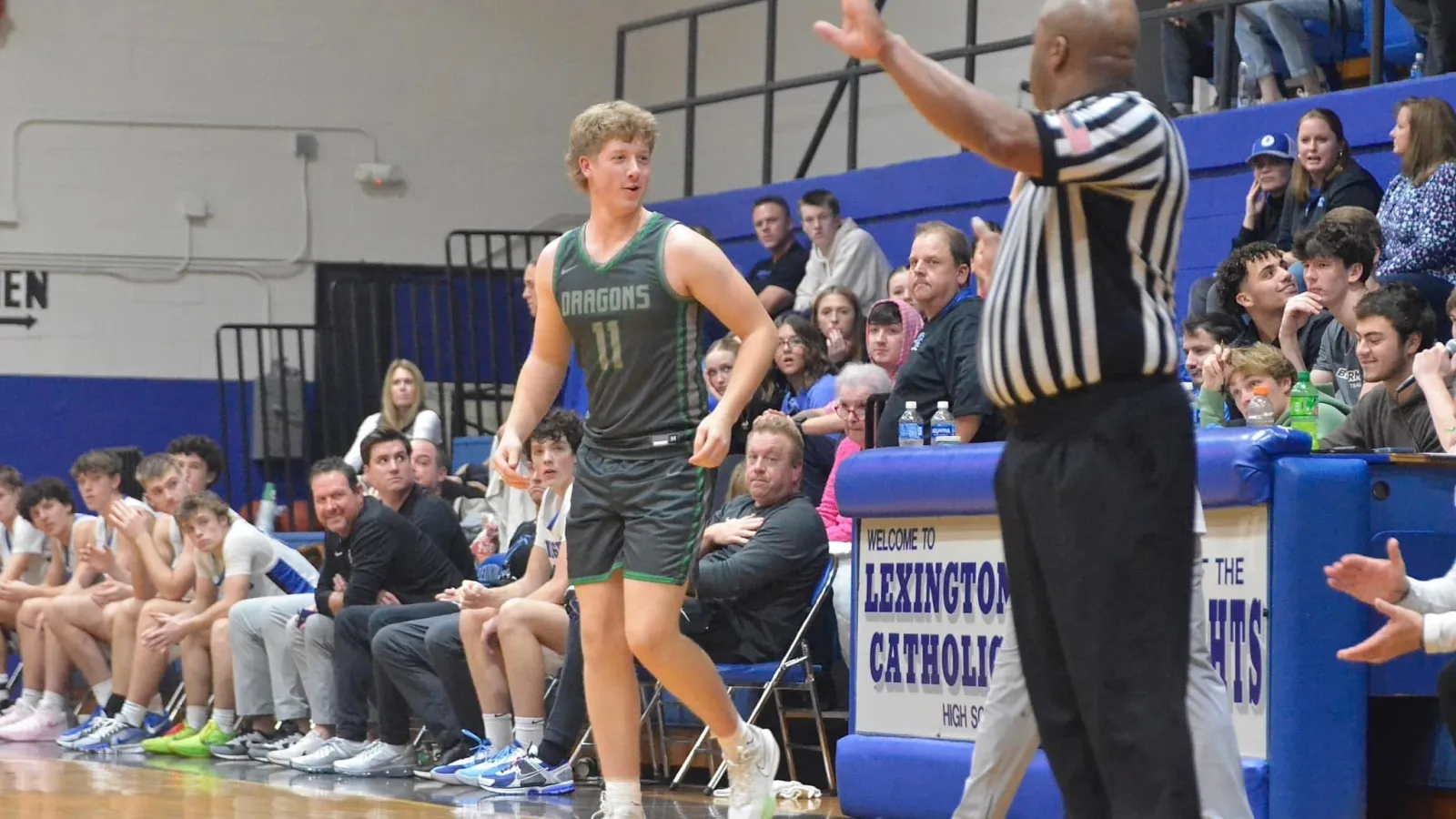 a person in a uniform at basketball game in front of crowd