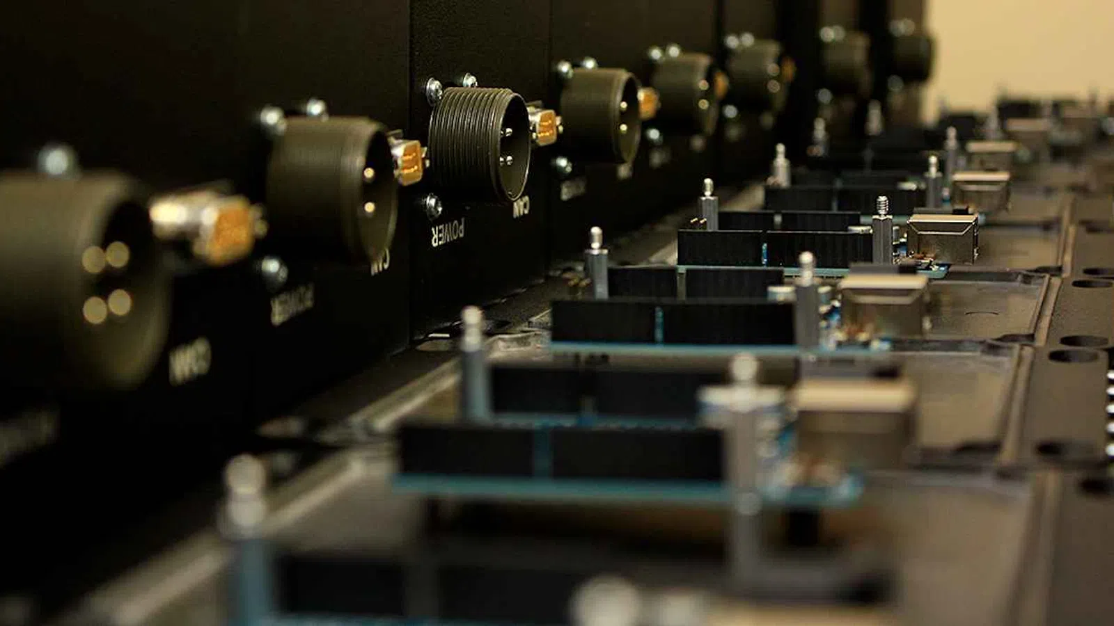 Close-up of electronic control panel knobs and connectors on a black device with shallow depth of field