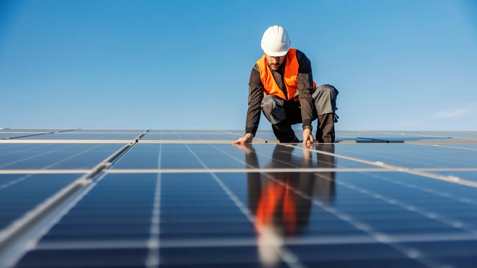a man kneeling on a solar panel
