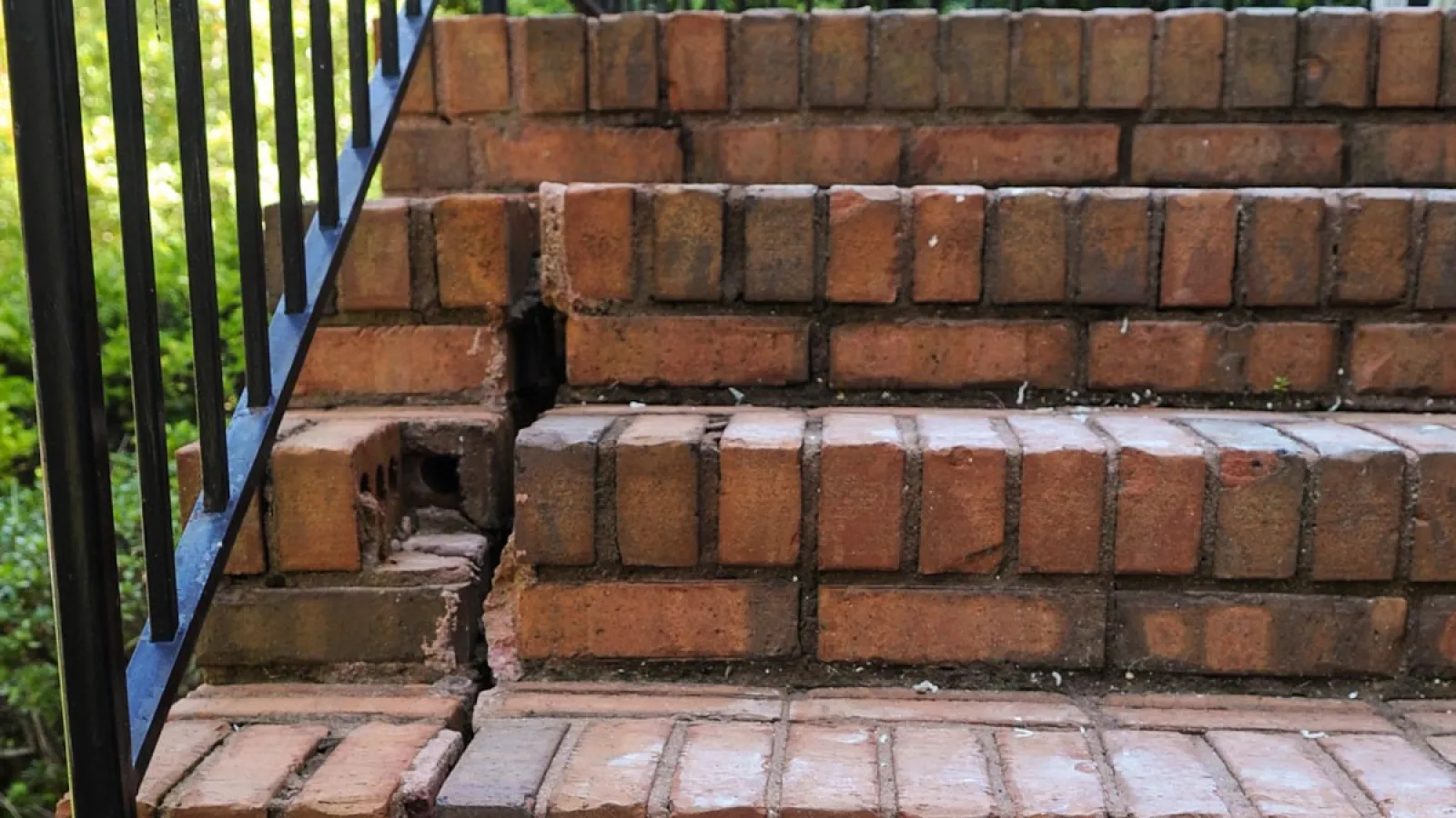 a brick wall with a metal railing