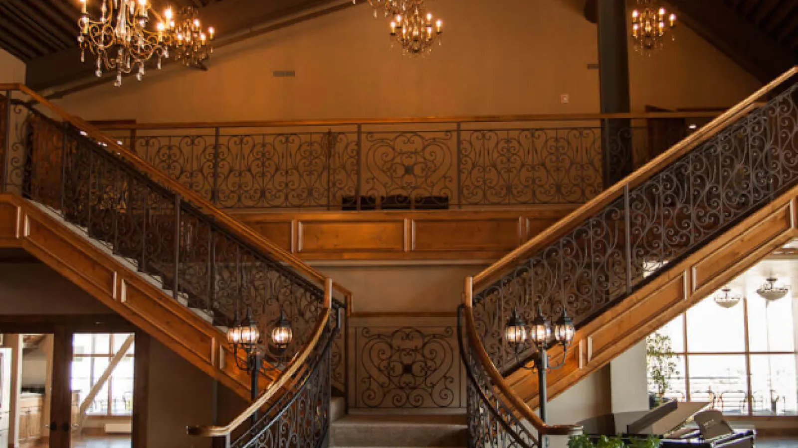 a staircase with a piano and chandelier