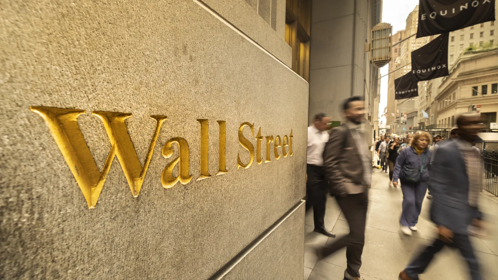 a group of people walking on a sidewalk