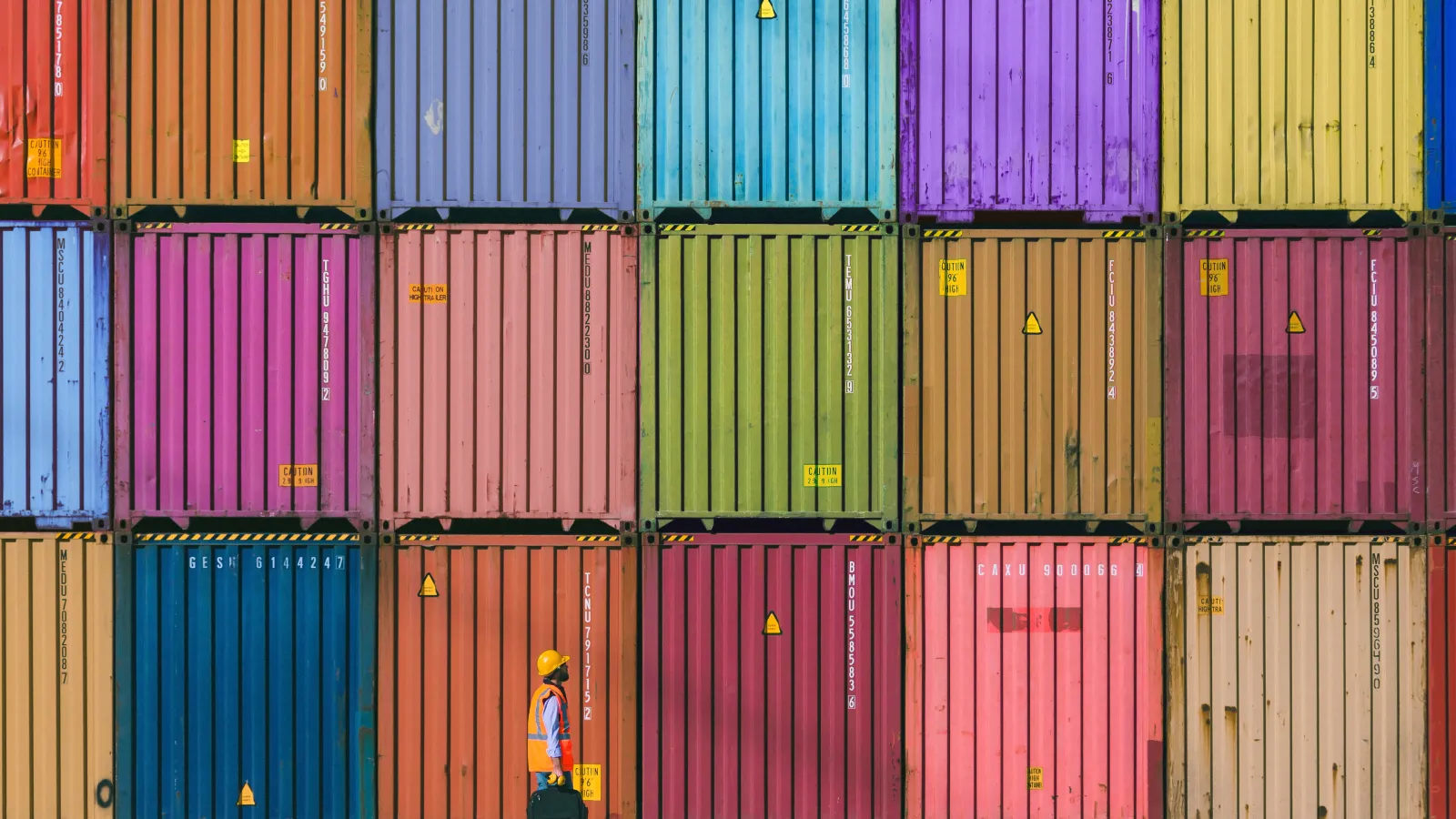 a person standing in front of a large pile of colorful containers