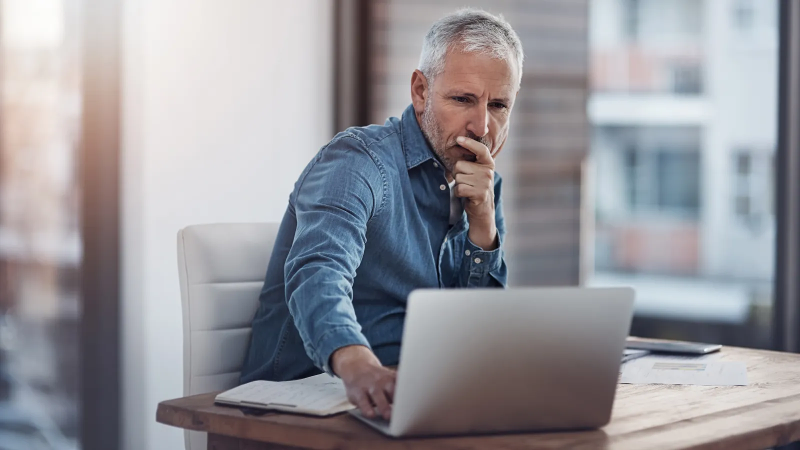 a person sitting at a table with a laptop and a book