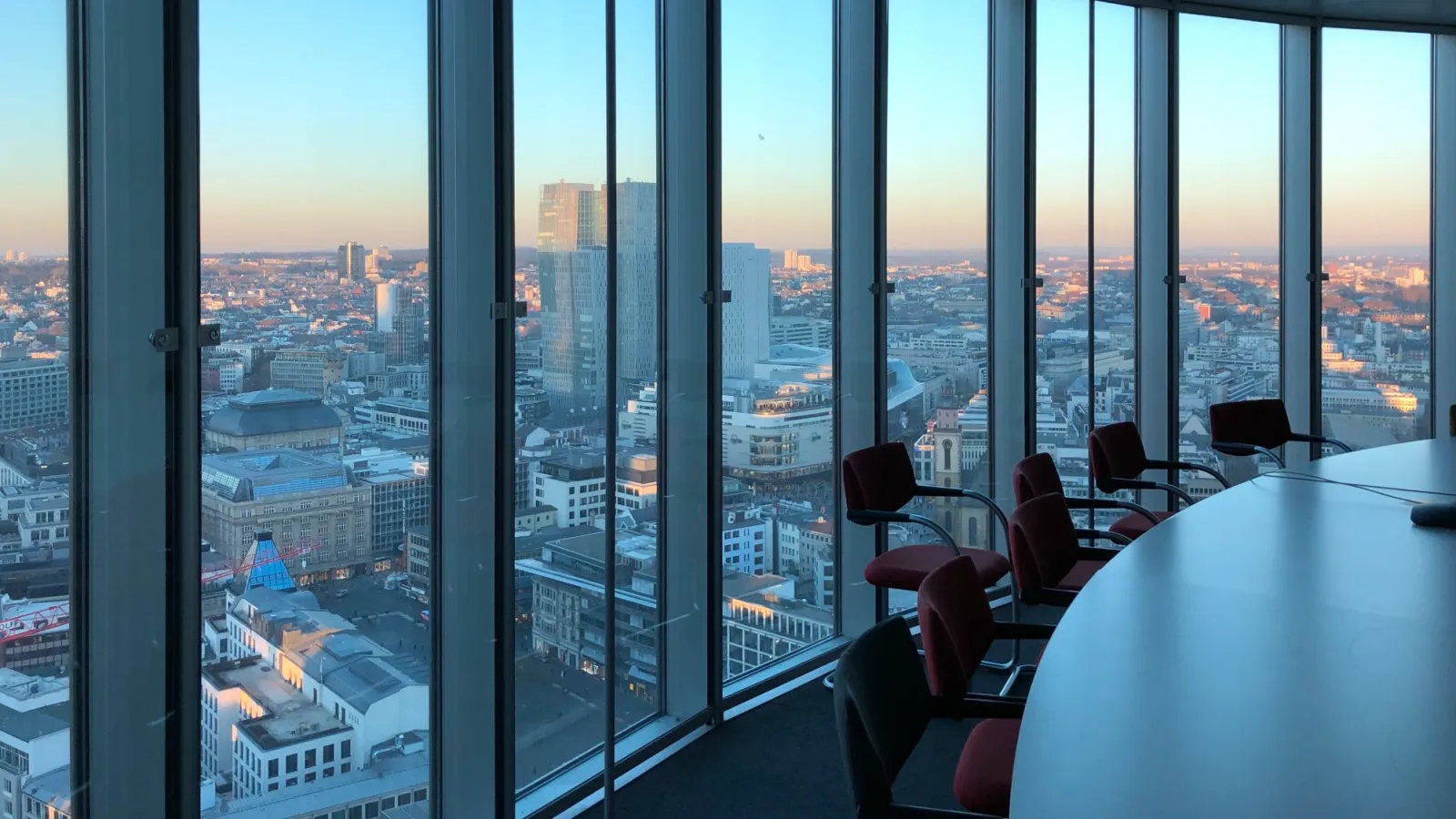 a room with a table and chairs and a window with a view of a city