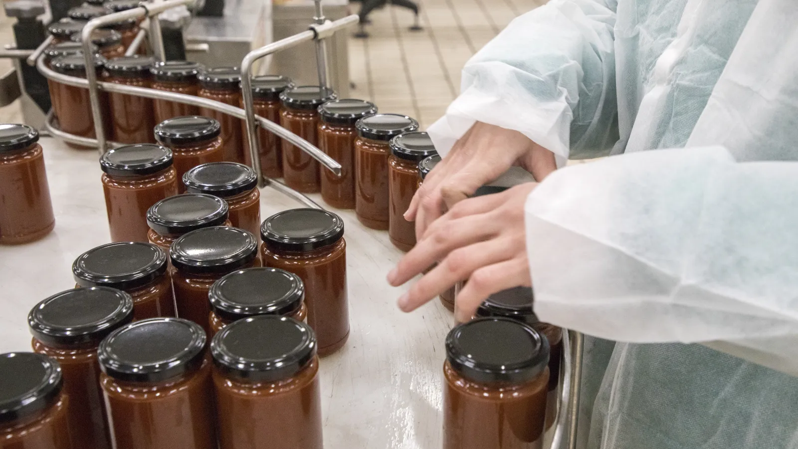 a person pouring a liquid into a jar