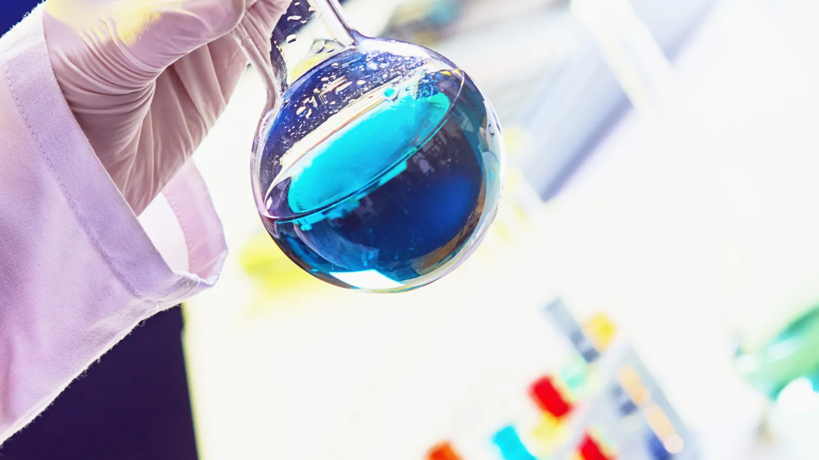 a person wearing gloves and a lab coat holding a magnifying glass
