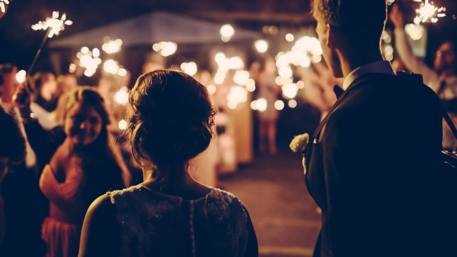 a man and woman holding sparklers