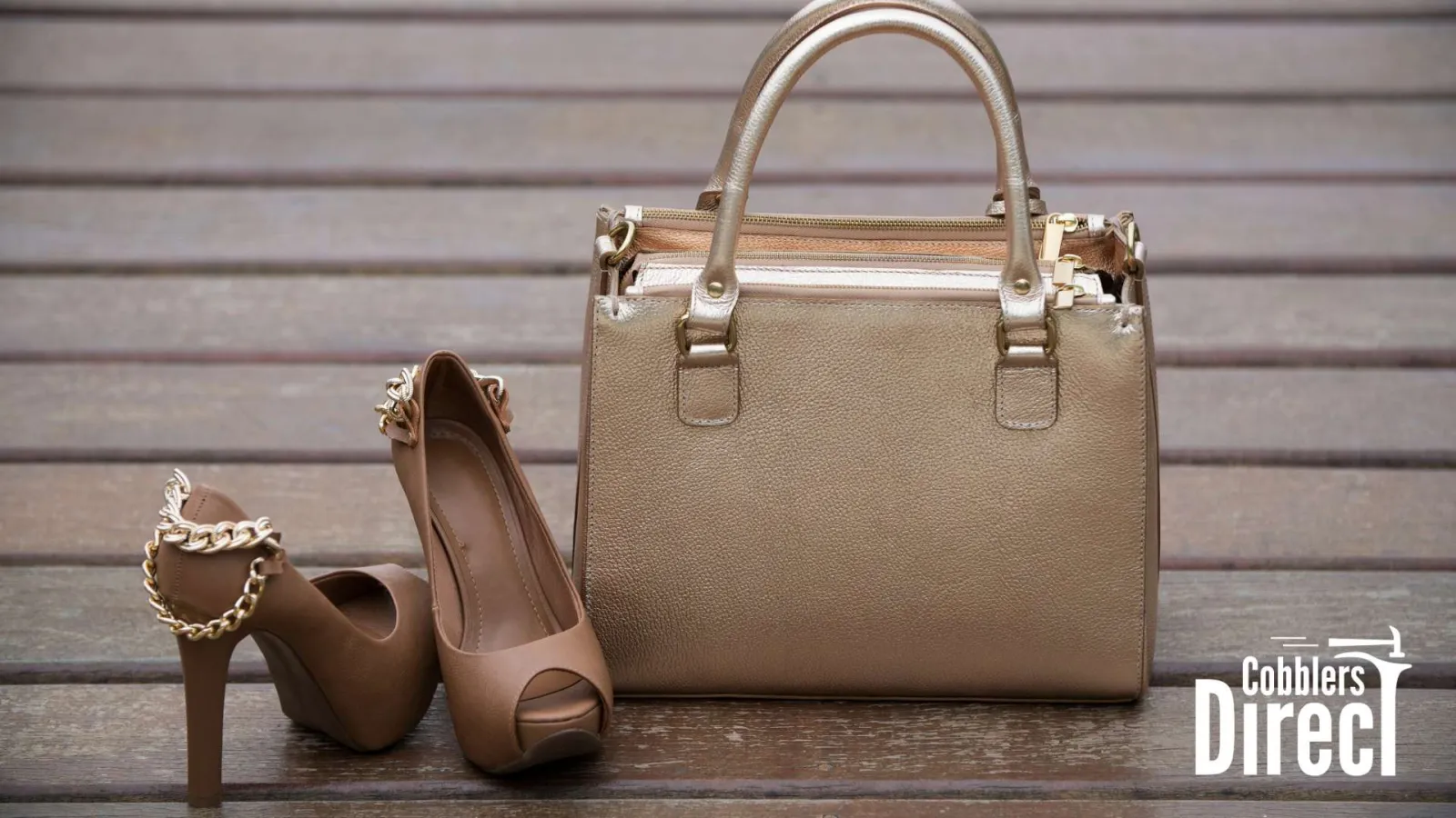 Beige high heels with gold chain accents and matching textured handbag on wooden floor.