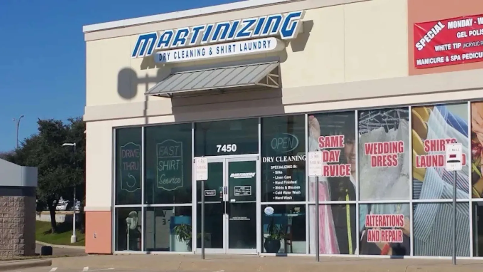 Martinizing dry cleaning and shirt laundry storefront with service signs and clear glass windows on a sunny day.