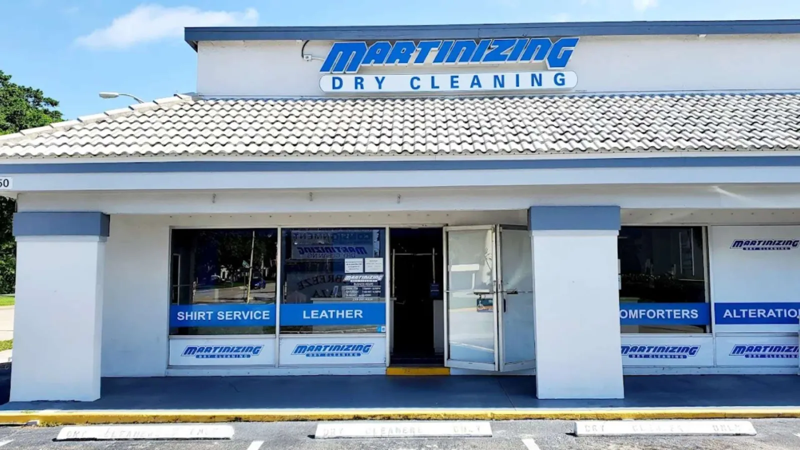 Front view of Martinizing Dry Cleaning store with signage and service windows for shirts, leather, and alterations