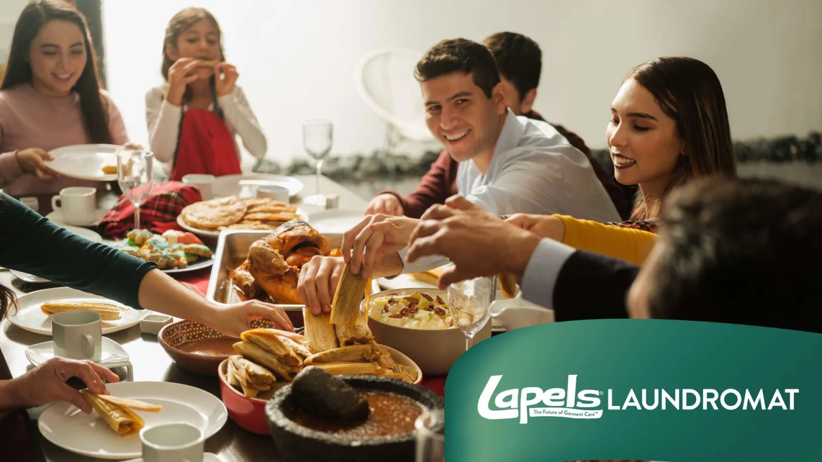 Group of friends sharing a meal with various traditional Mexican dishes at a festive table gathering