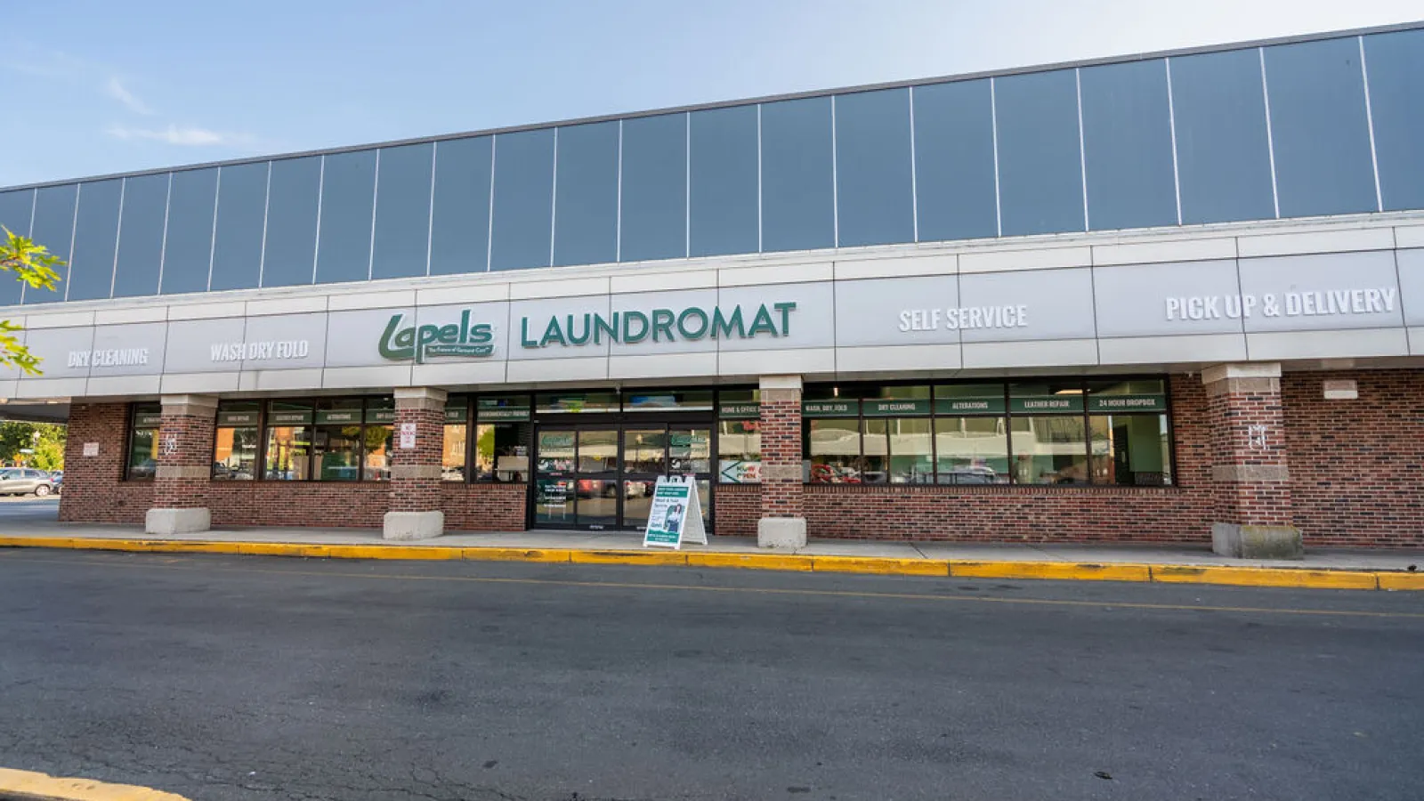 Lapels Laundromat storefront with signs for dry cleaning, wash dry fold, self service, pick up, and delivery