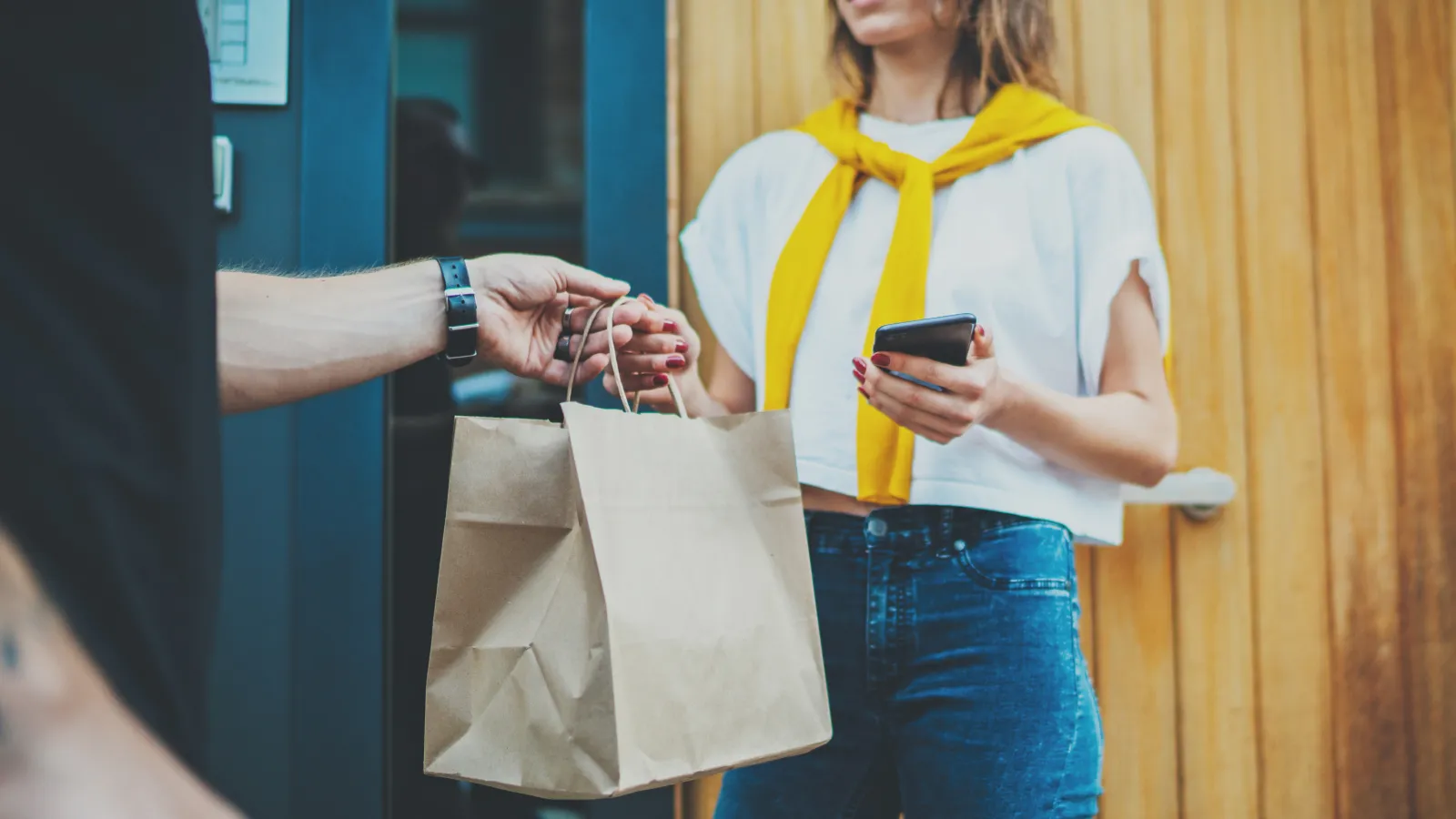 a person holding a phone and a bag