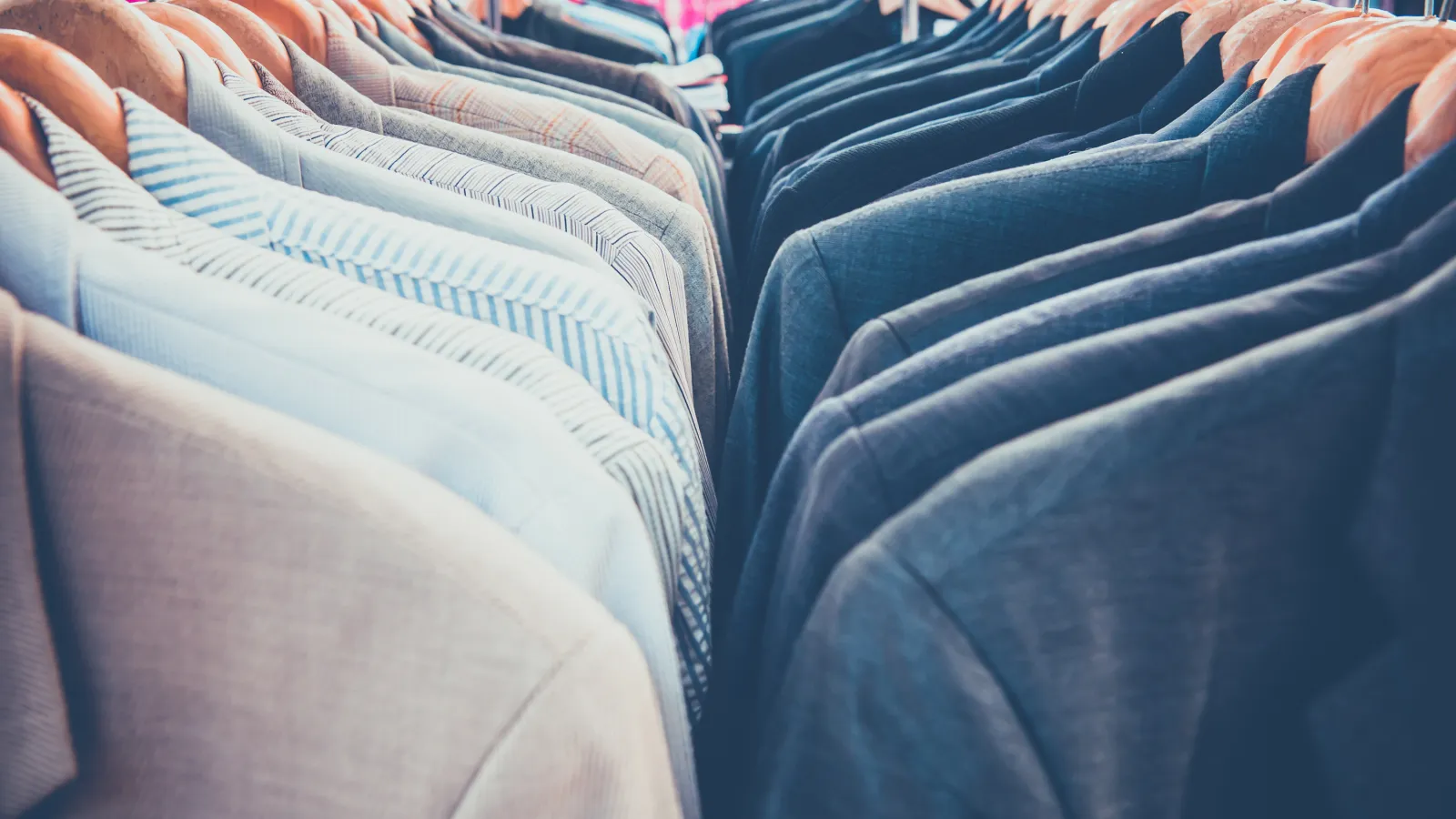 several dress shirts and suits hung up