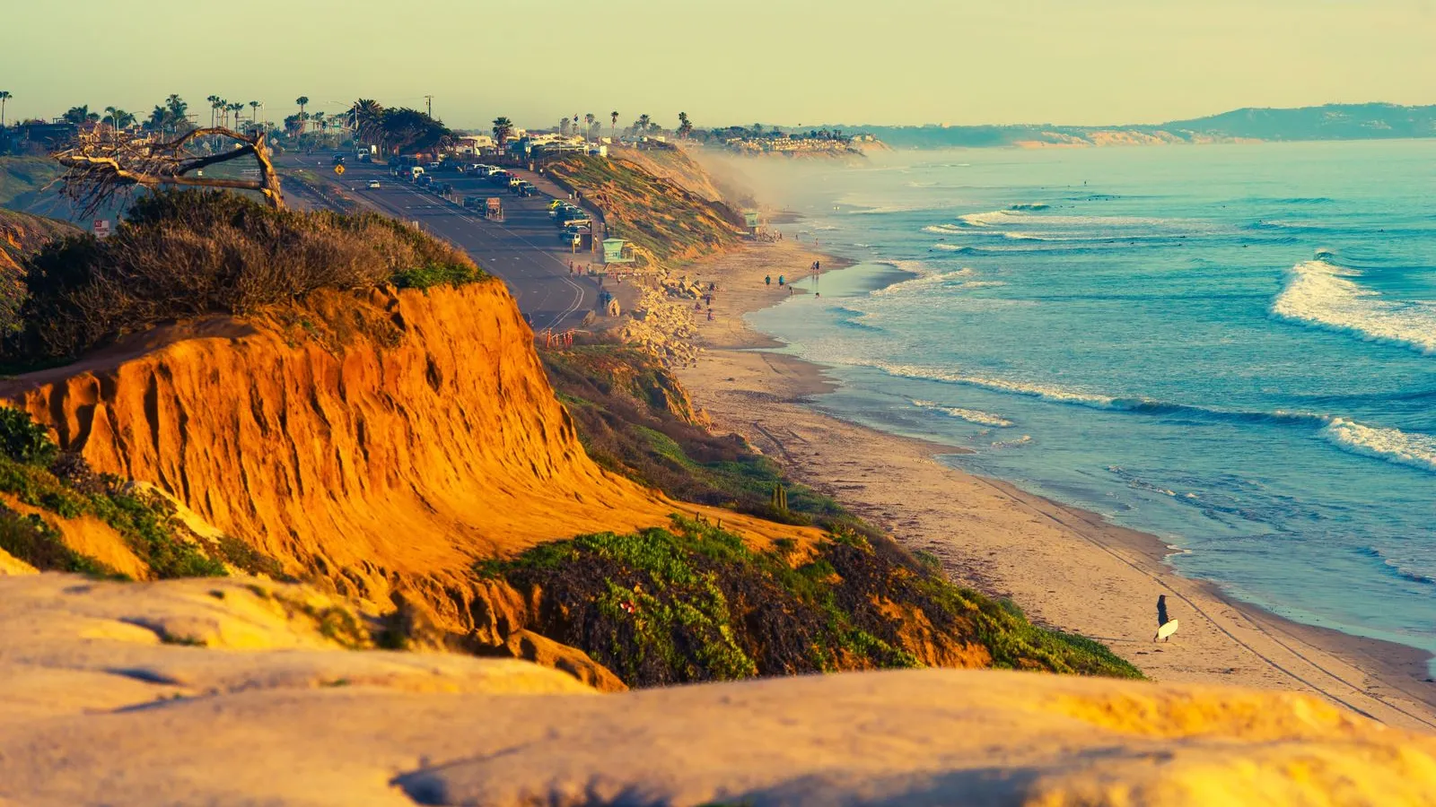 a beach with a cliff and water