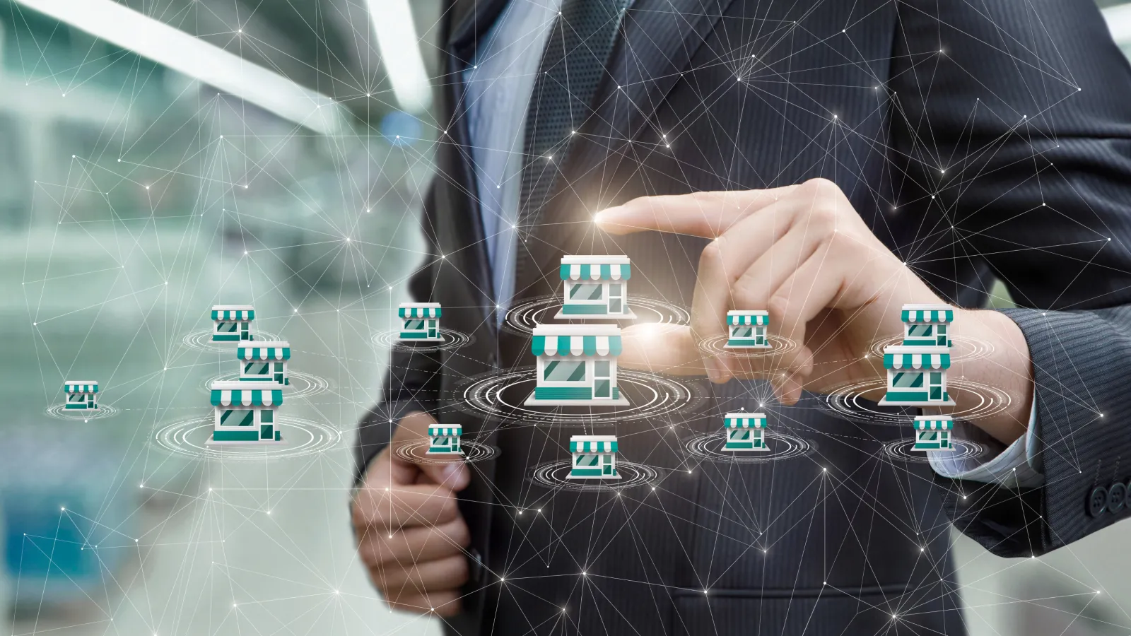 Businessman in suit interacting with digital franchise icons representing network and expansion strategies.