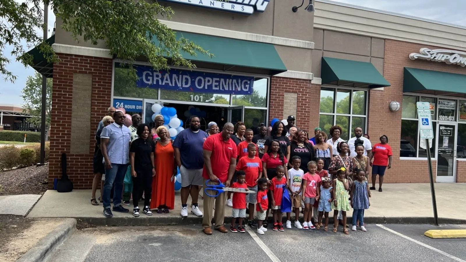 a group of people posing for a photo in front of a store