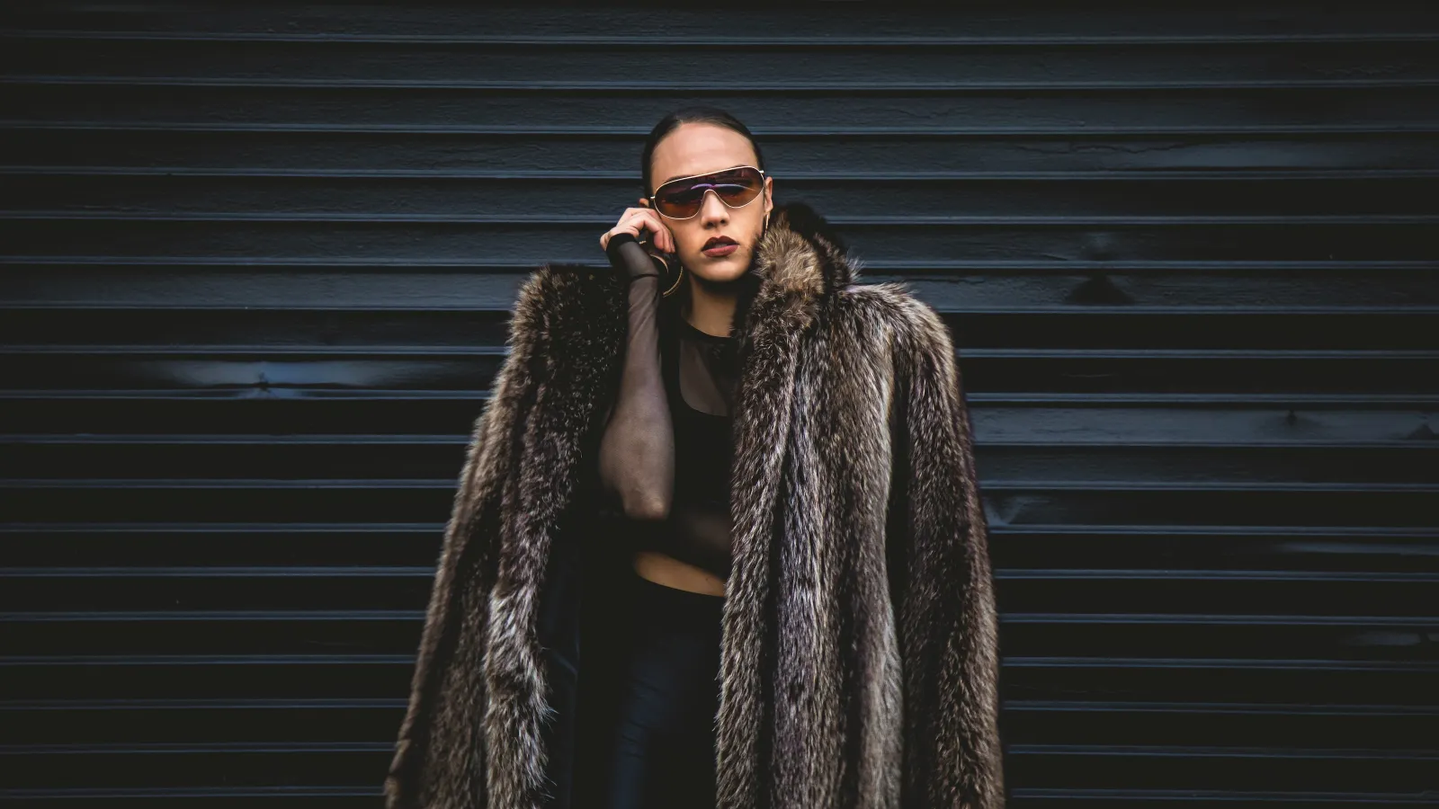 a woman wearing sunglasses and a fur jacket
