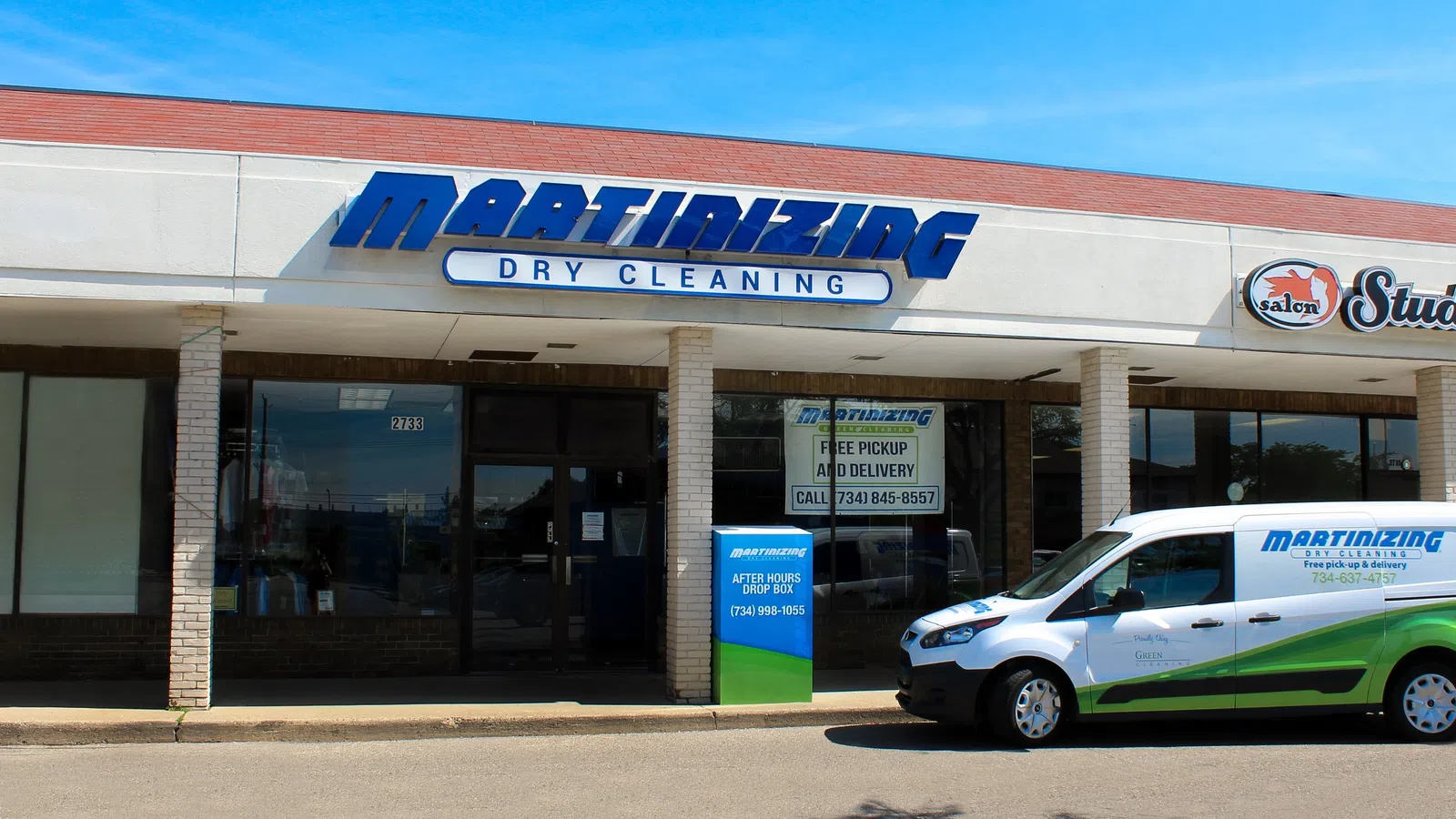Exterior view of Martinizing Cleaners storefront with branded service van parked outside on a clear day in Ann Arbor