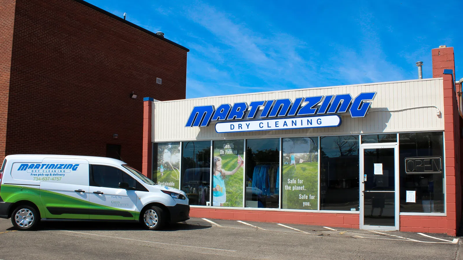 Martinizing Cleaners storefront with a branded van parked outside on a sunny day in Ann Arbor