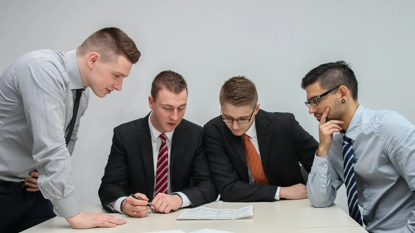 a group of men looking at papers