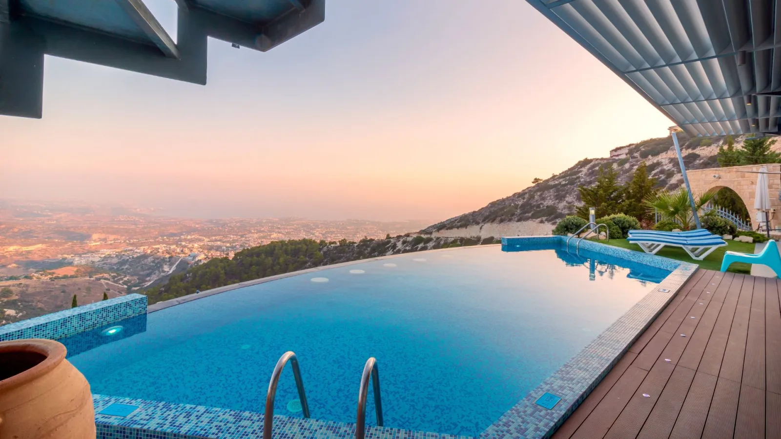 a pool with a deck and a view of a city and mountains
