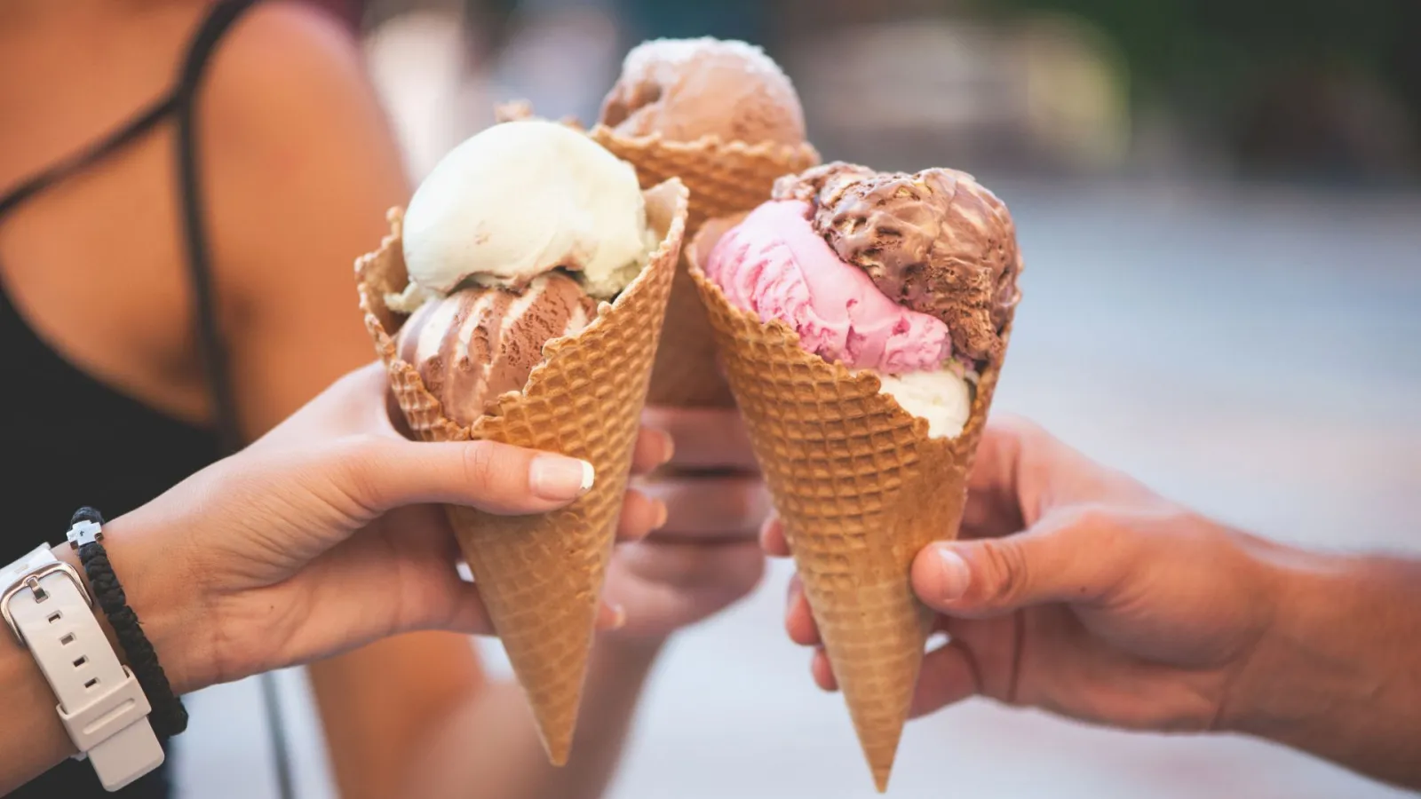 a person holding ice cream cones